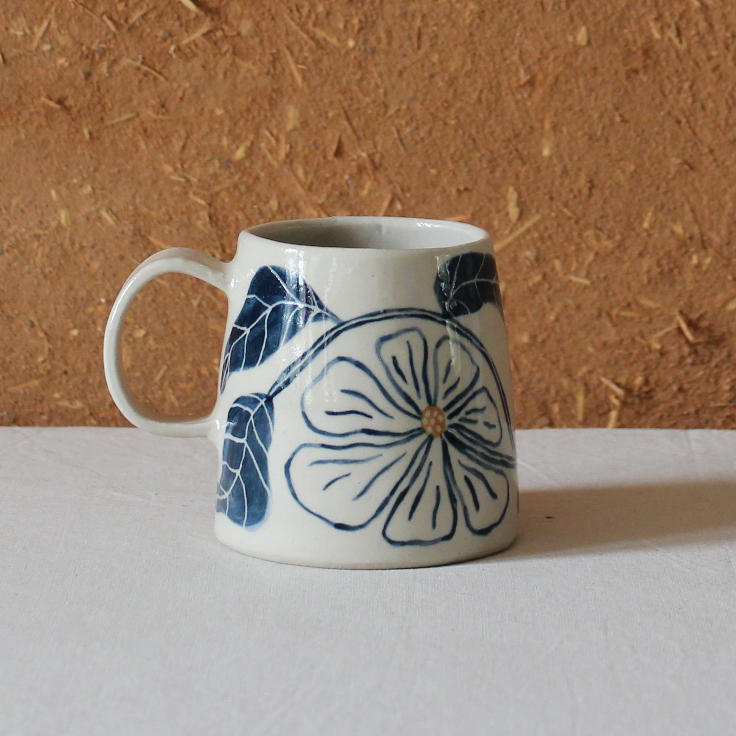  Vue de profil d’une tasse à anse conique à base large, en grès, motif Floral, création artisanale à Nanteau-sur-Lunain 