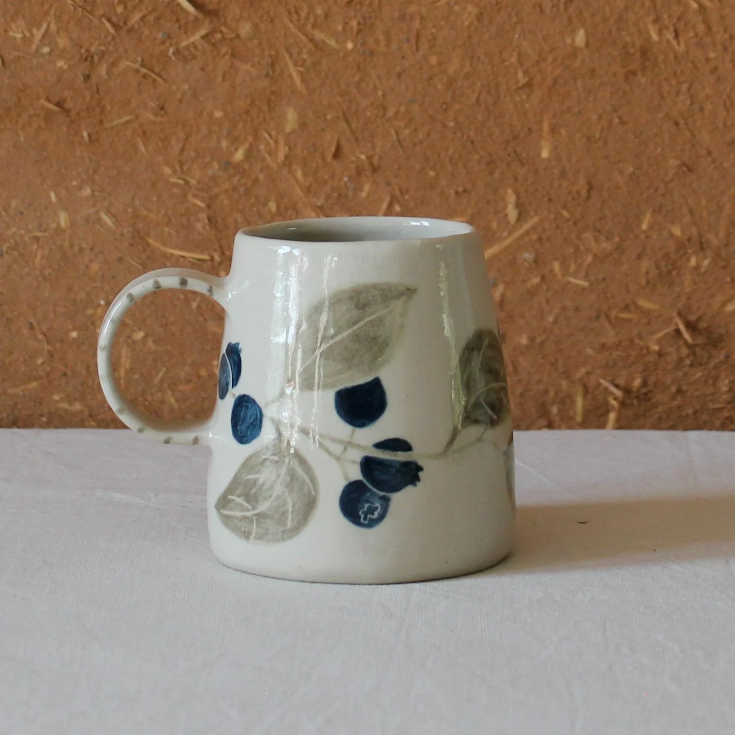  Vue de profil d’une tasse à anse conique à base large, en grès, motif Myrtille, création artisanale à Nanteau-sur-Lunain 