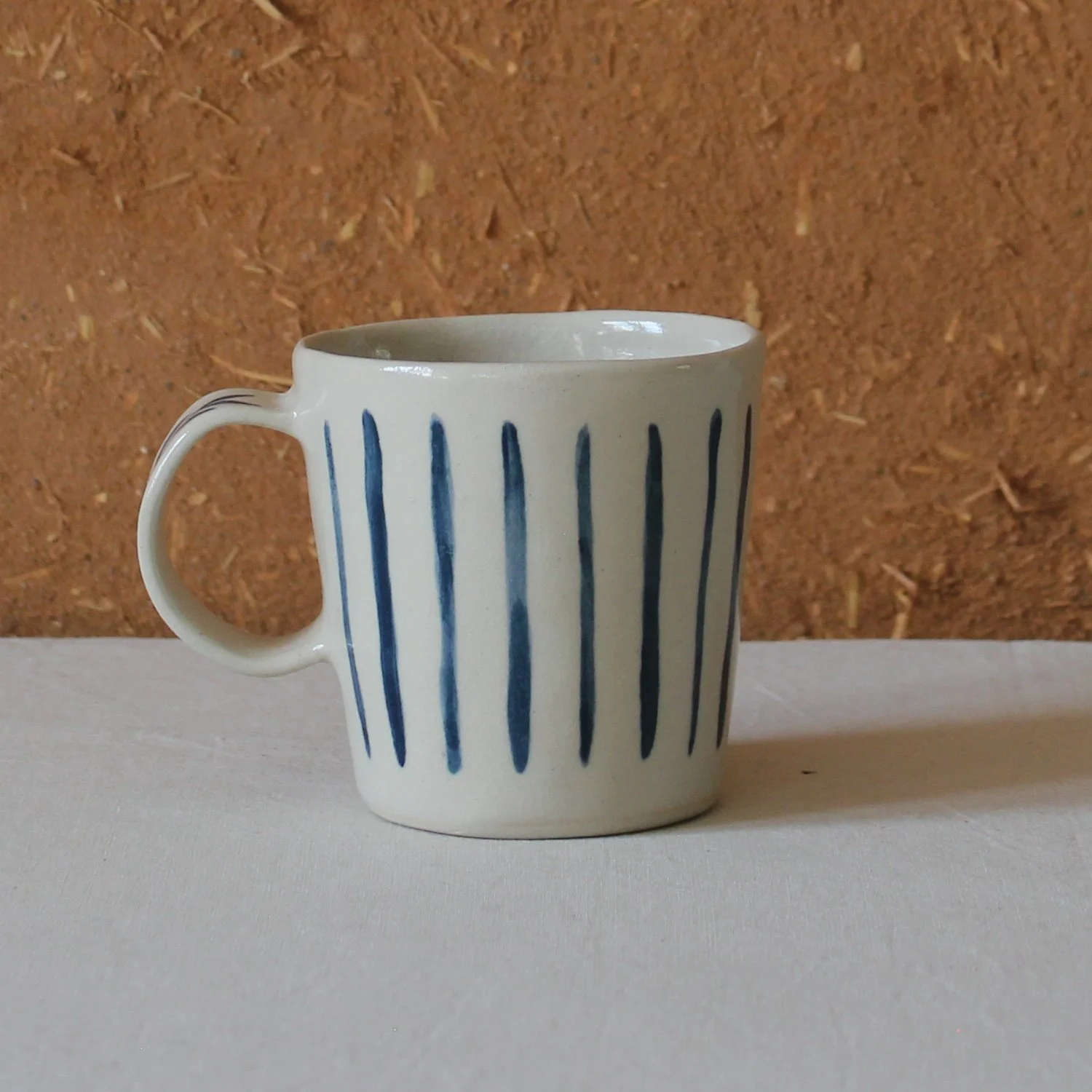  Vue de profil d’une tasse à anse conique à base étroite, en grès, motif Rayures et saule, création artisanale à Nanteau-sur-Lunain 