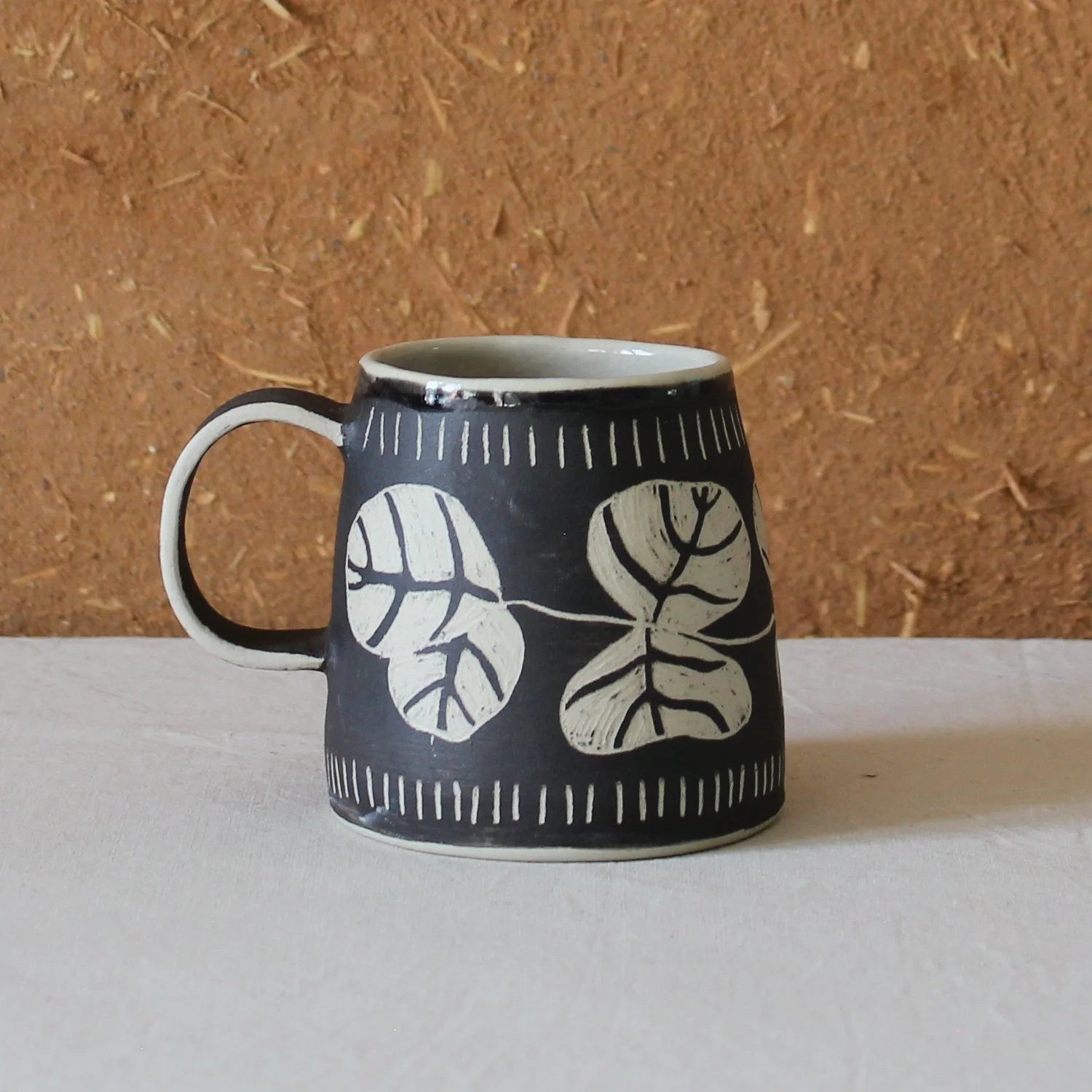  Vue de profil d’une tasse à anse conique à base large, en grès, motif Eucalyptus (sgraffito), création artisanale à Nanteau-sur-Lunain 