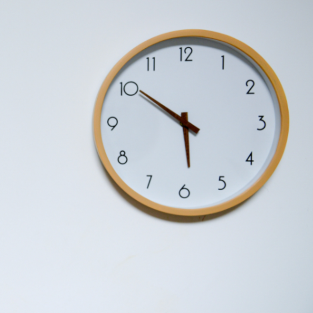 Wall clock with a beige frame showing 10:08