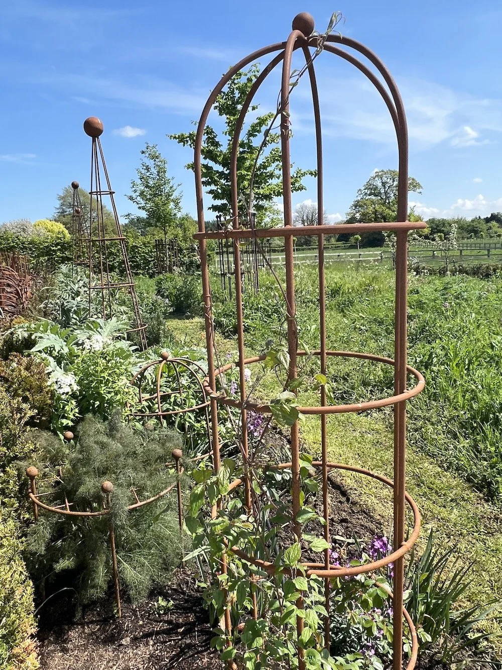 Cages and obelisks give height to a border