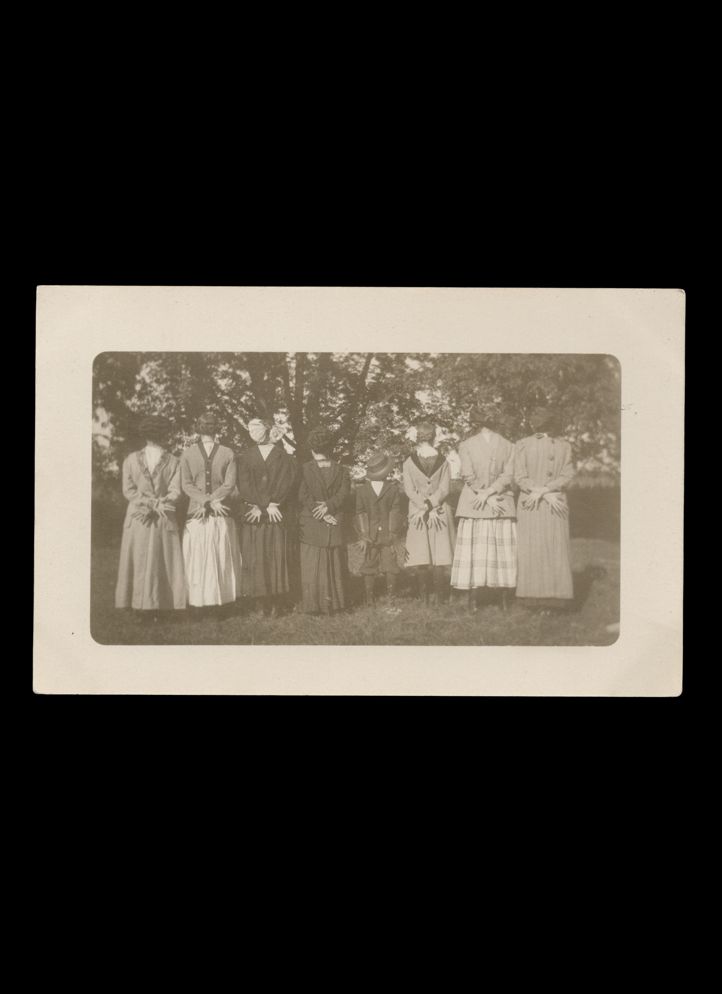 Back-to-Camera Group Portrait of 8 Figures Wearing Clothing Backwards, real-photo postcard, c. 1910