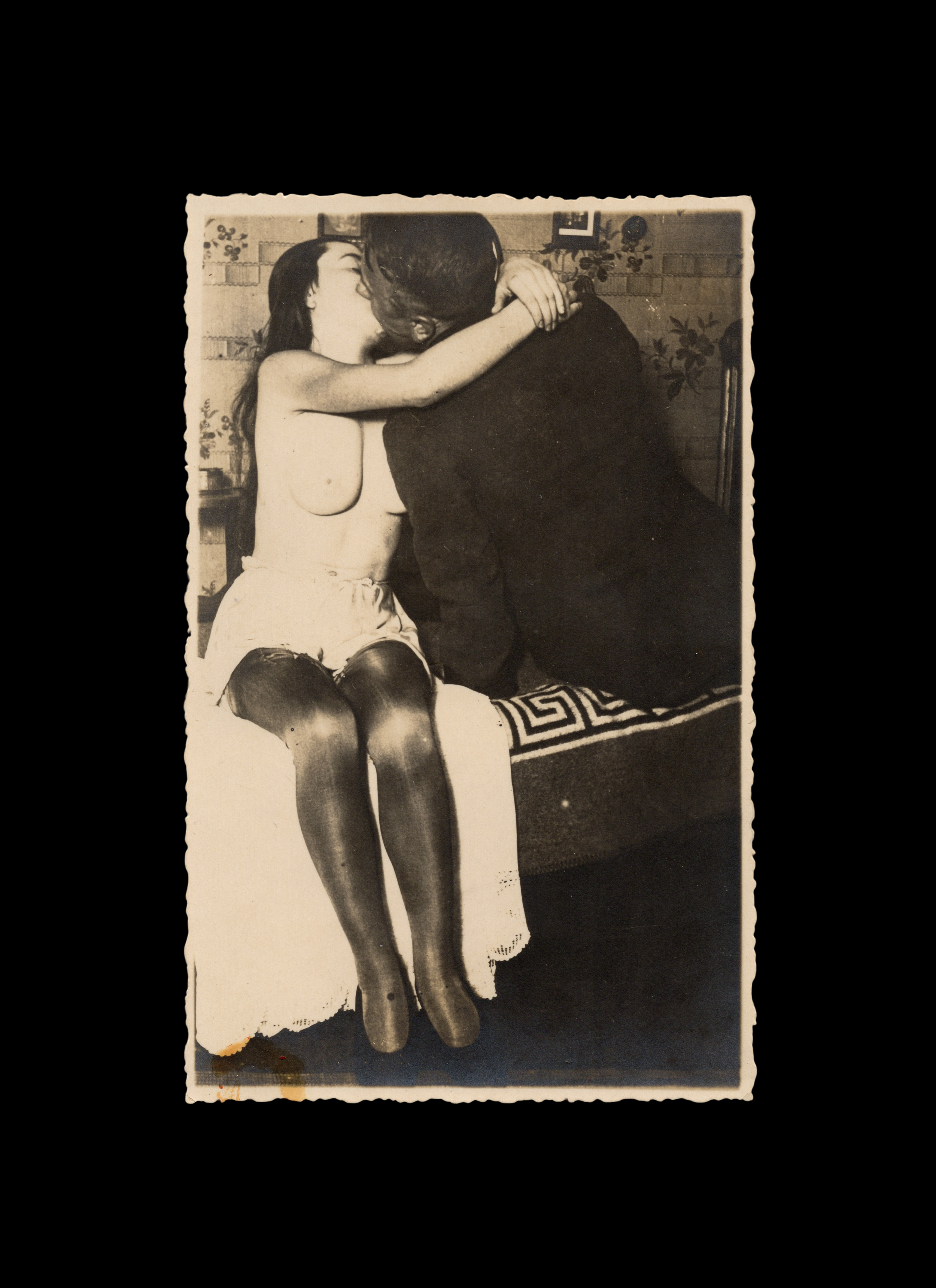 Couple Sitting on Bed with Faces Obscured from Kissing, real-photo postcard,  c. 1930
