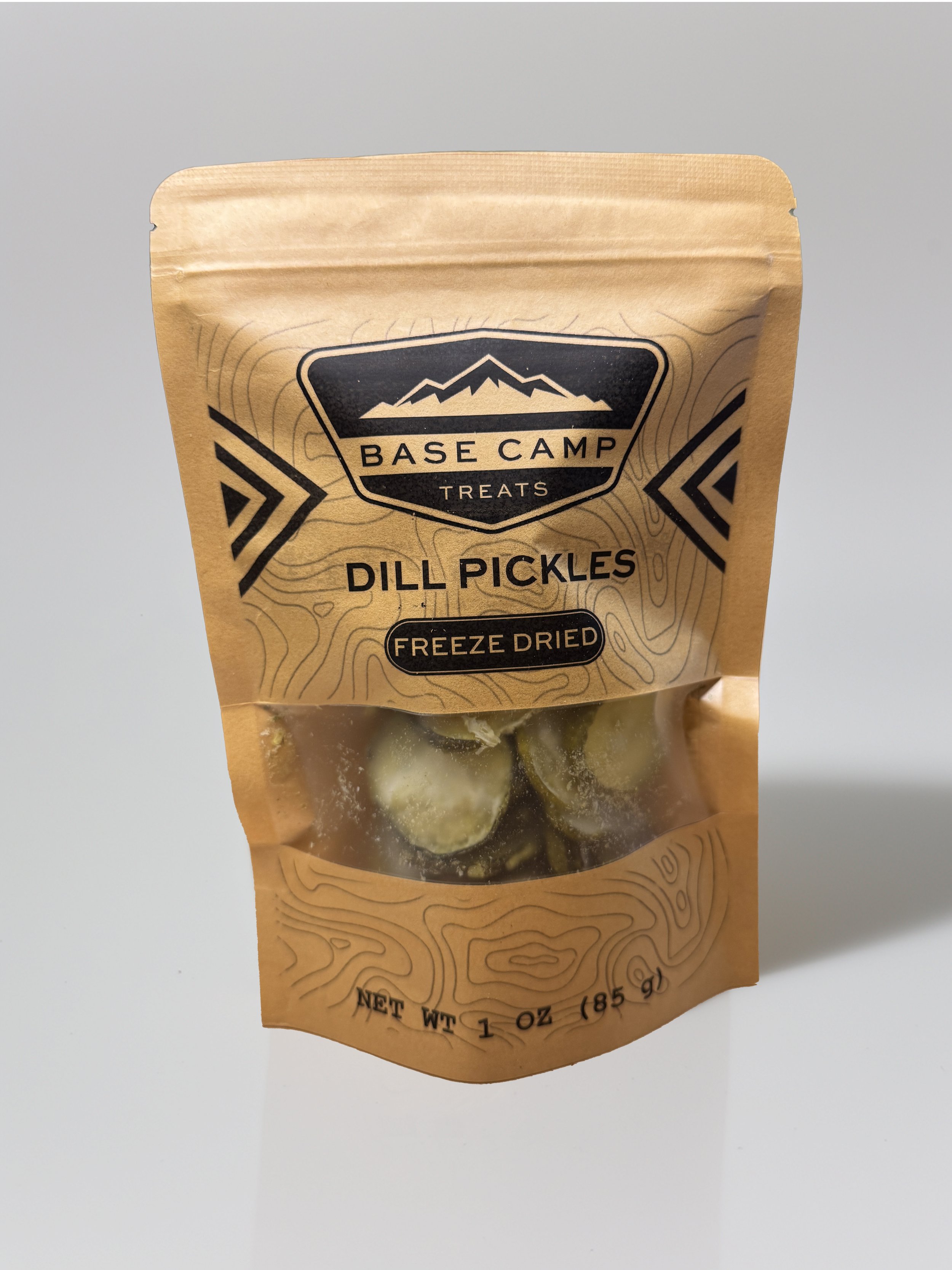 Base Camp Treats Freeze Dried Dill Pickles in kraft stand-up pouch with crunchy pickle chips visible through clear window.