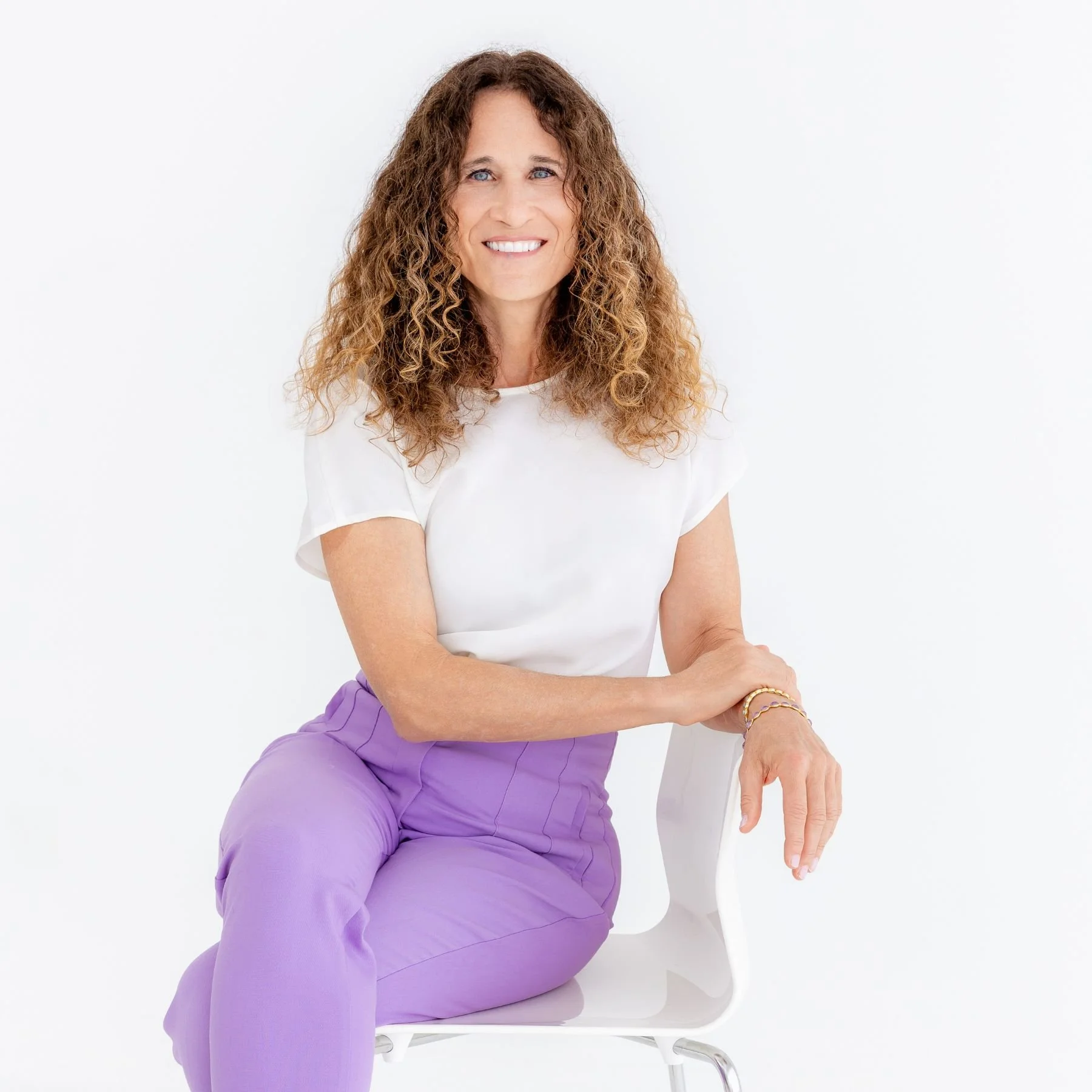 Pet industry consultant Erin Fenstermaker in a white shirt with lavendar pants on a white chair