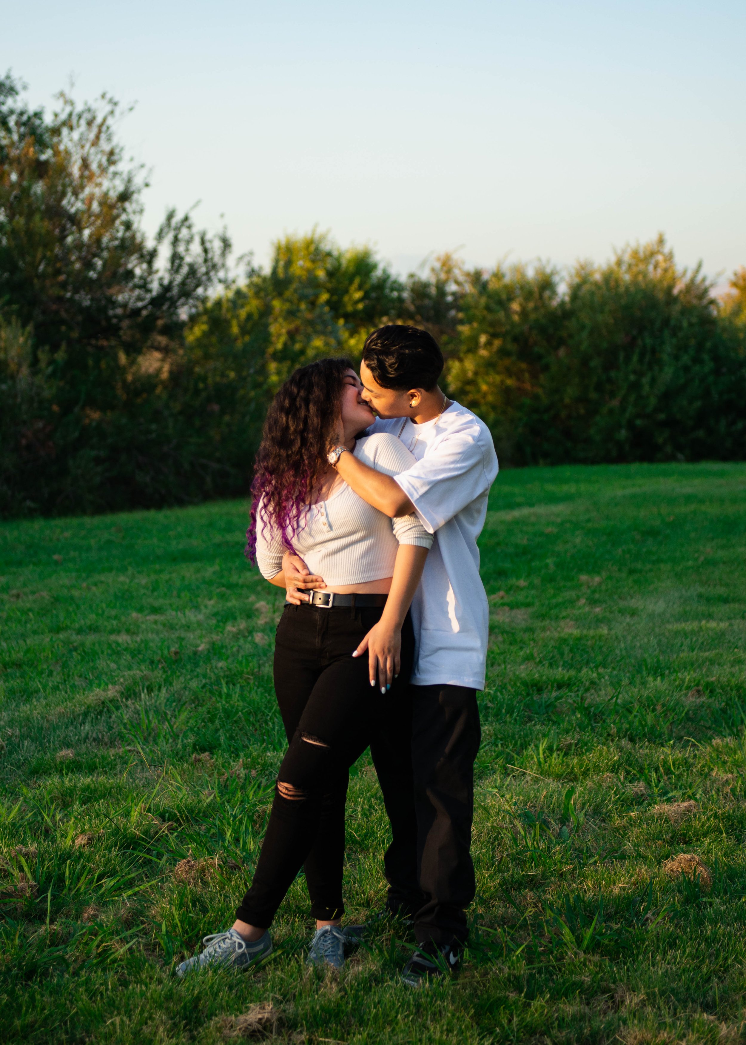 Candid portrait of couple holding each other kissing at sandy canyon trail in irvine