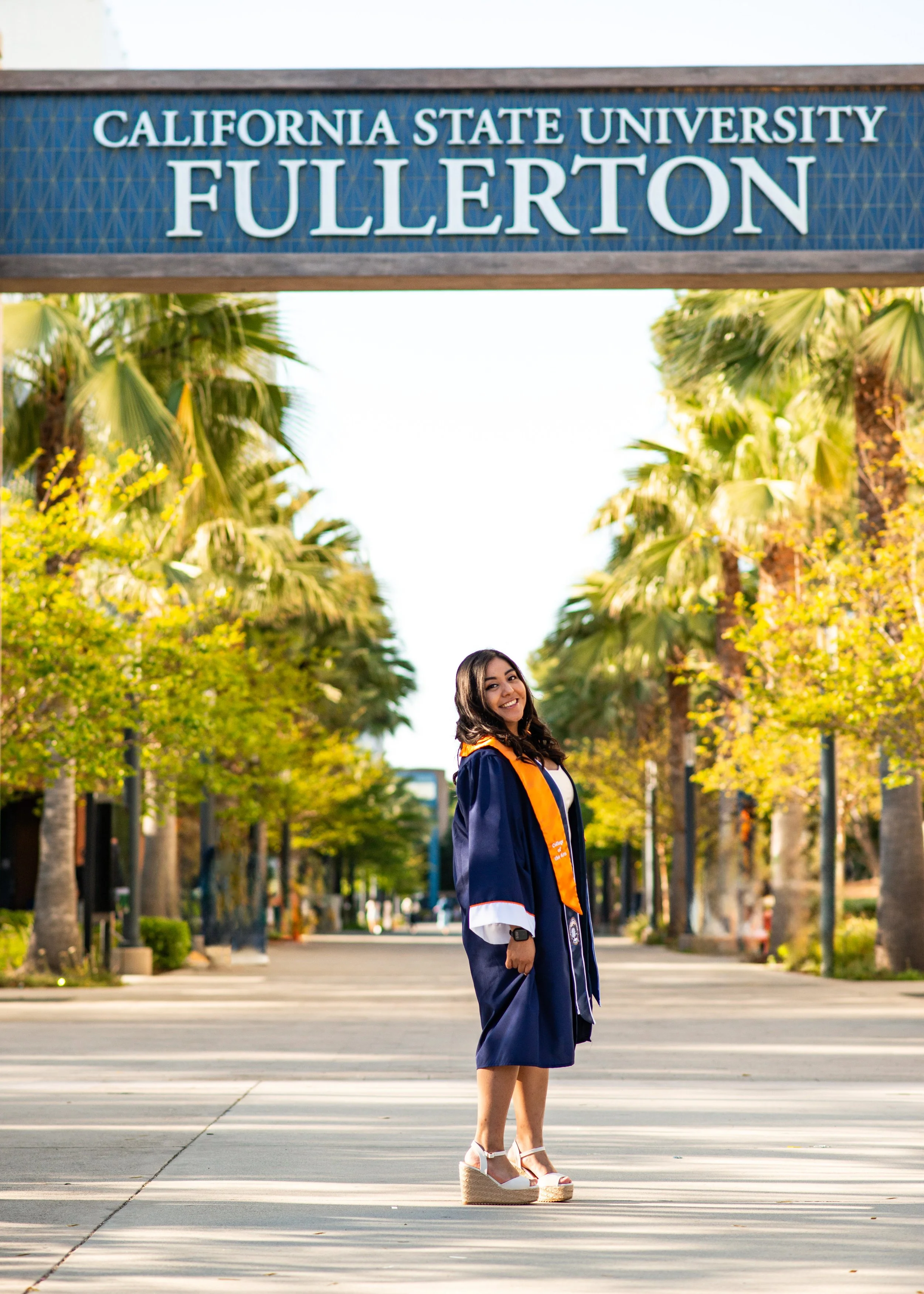 Graduation photo of Jenny in front of Cal State Fullerton sign 