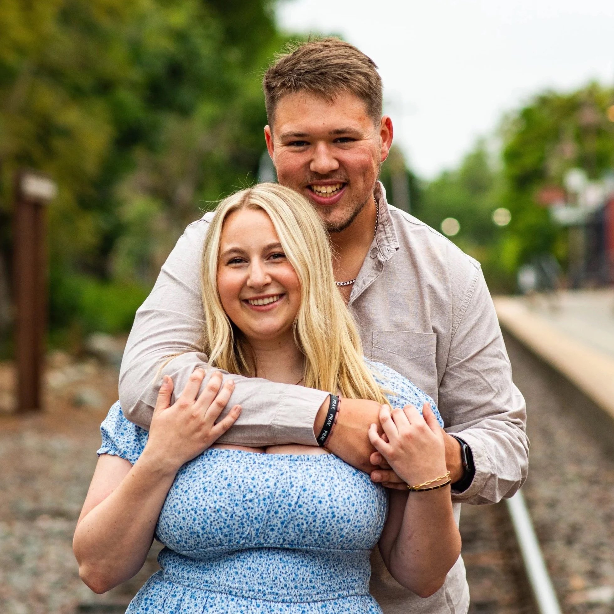Portrait of couple holding each other on train tracks