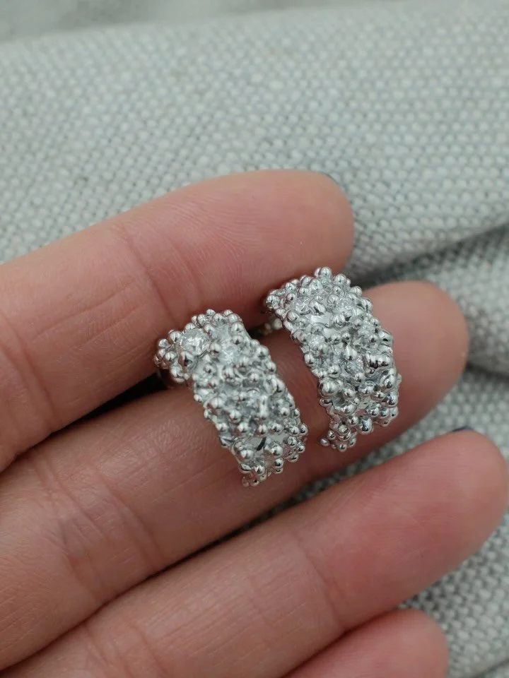 A gorgeous set of White Gold Huggie hoop earrings. Decorated with clusters of granulation and set with sparkling white diamonds that shimmer away subtly in their midst.

A special pair of earrings commissioned for Christmas and set with heirloom diam