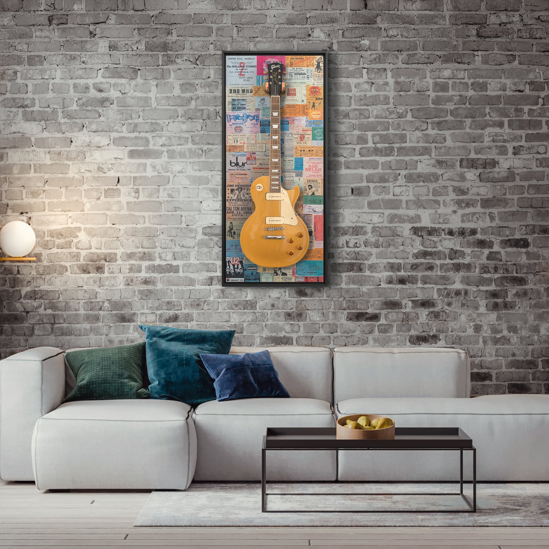 A wall mounted guitar hanger hanging a guitar above a sofa