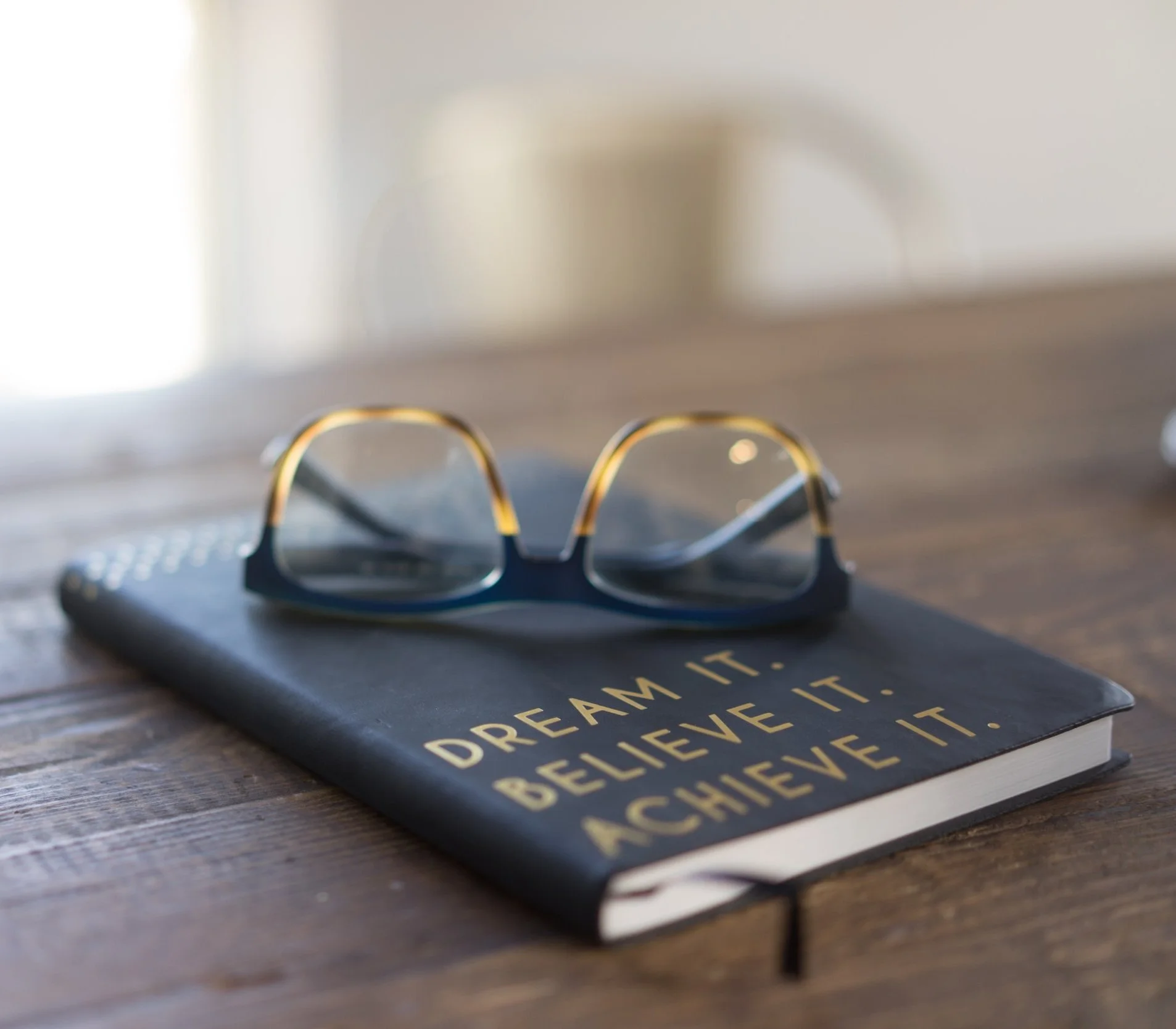 Glasses sitting on a journal with sun coming in through the window
