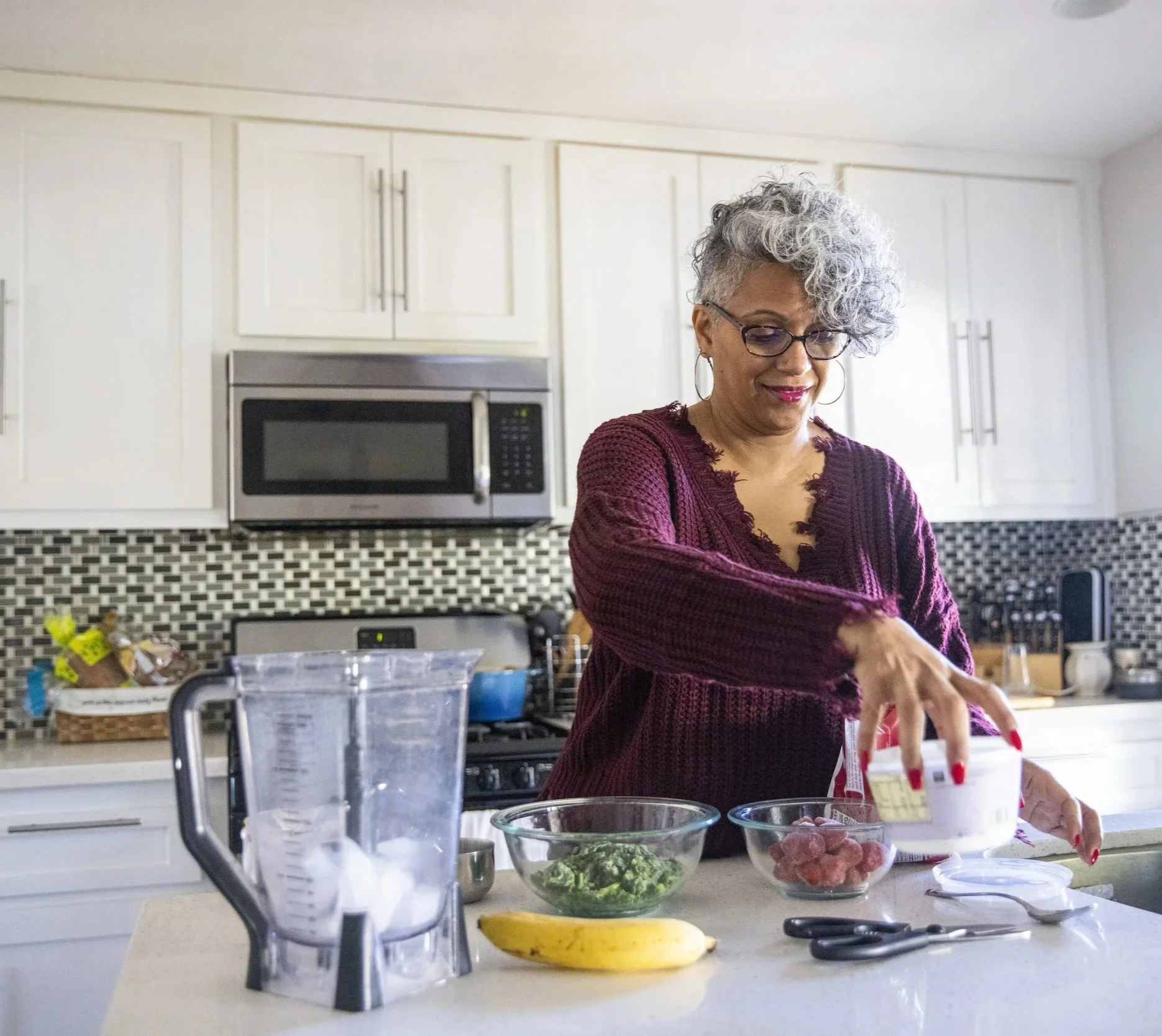 Woman in a kitchen preparing something in a blender