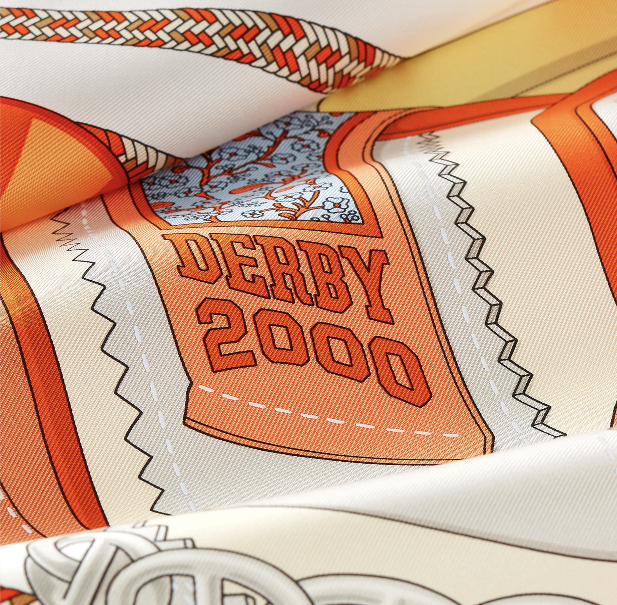 Cette photographie en gros plan met en lumière les détails et la texture soyeuse du carré de soie Hermès. L'image se focalise sur une illustration graphique texturée représentant une languette ou un empiècement de chaussure rétro. Au centre, l'inscri