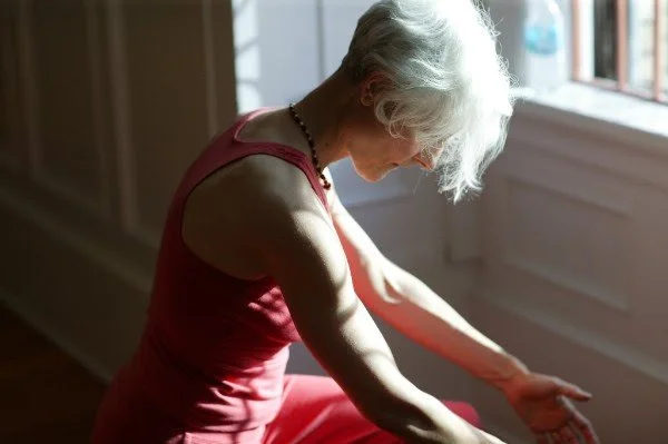 seated woman with gray hair and bowed head