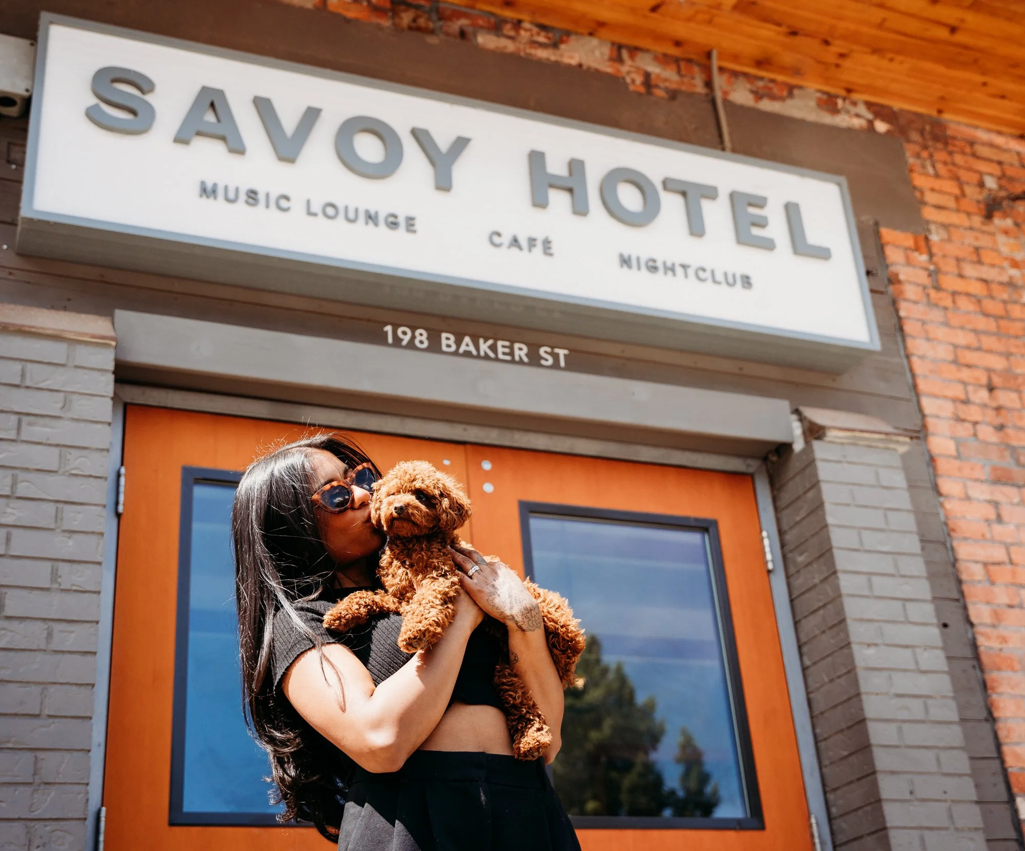 A hotel guest holds a small dog outside a pet-friendly hotel in Nelson BC.