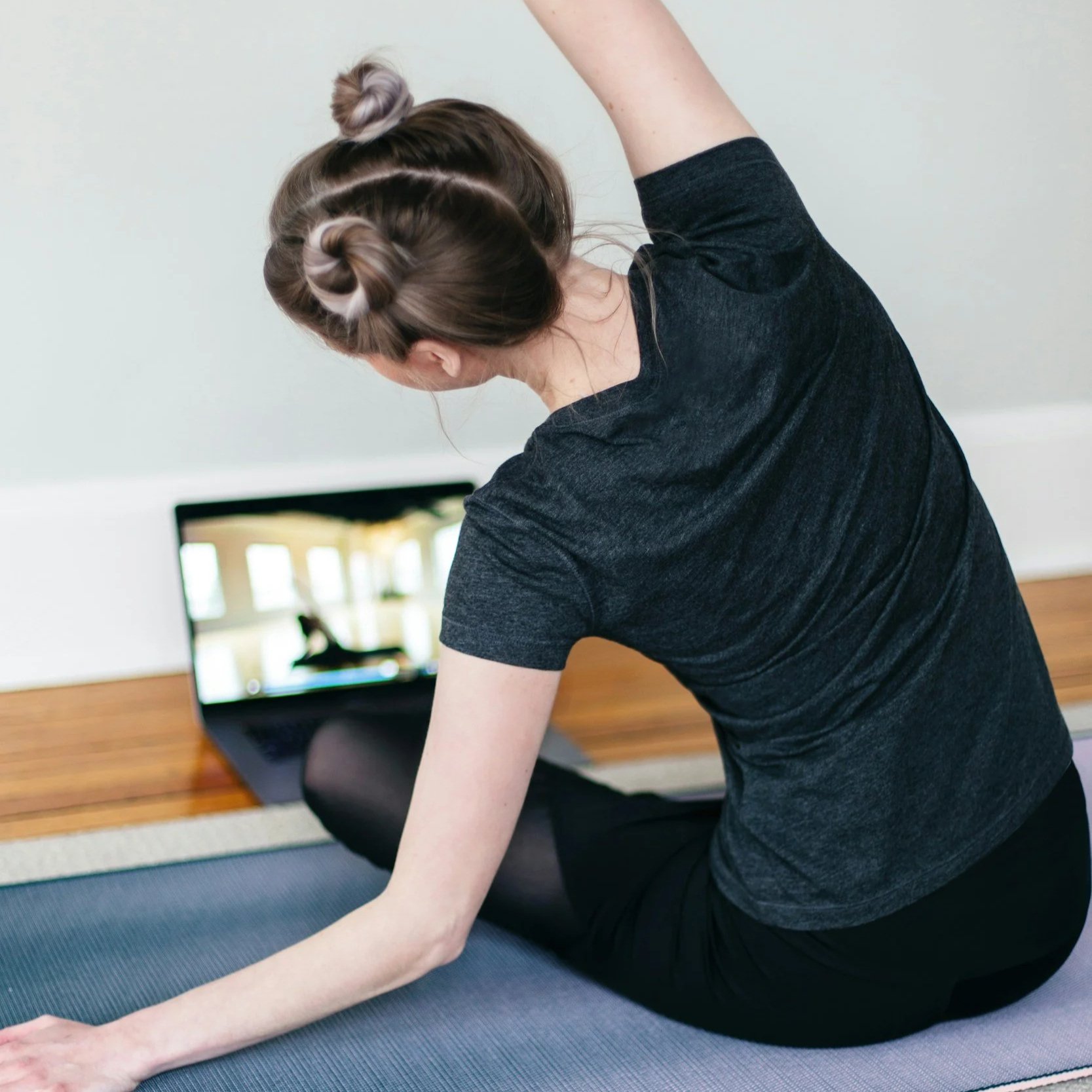 A person is enjoying a virtual online yoga class in her home.