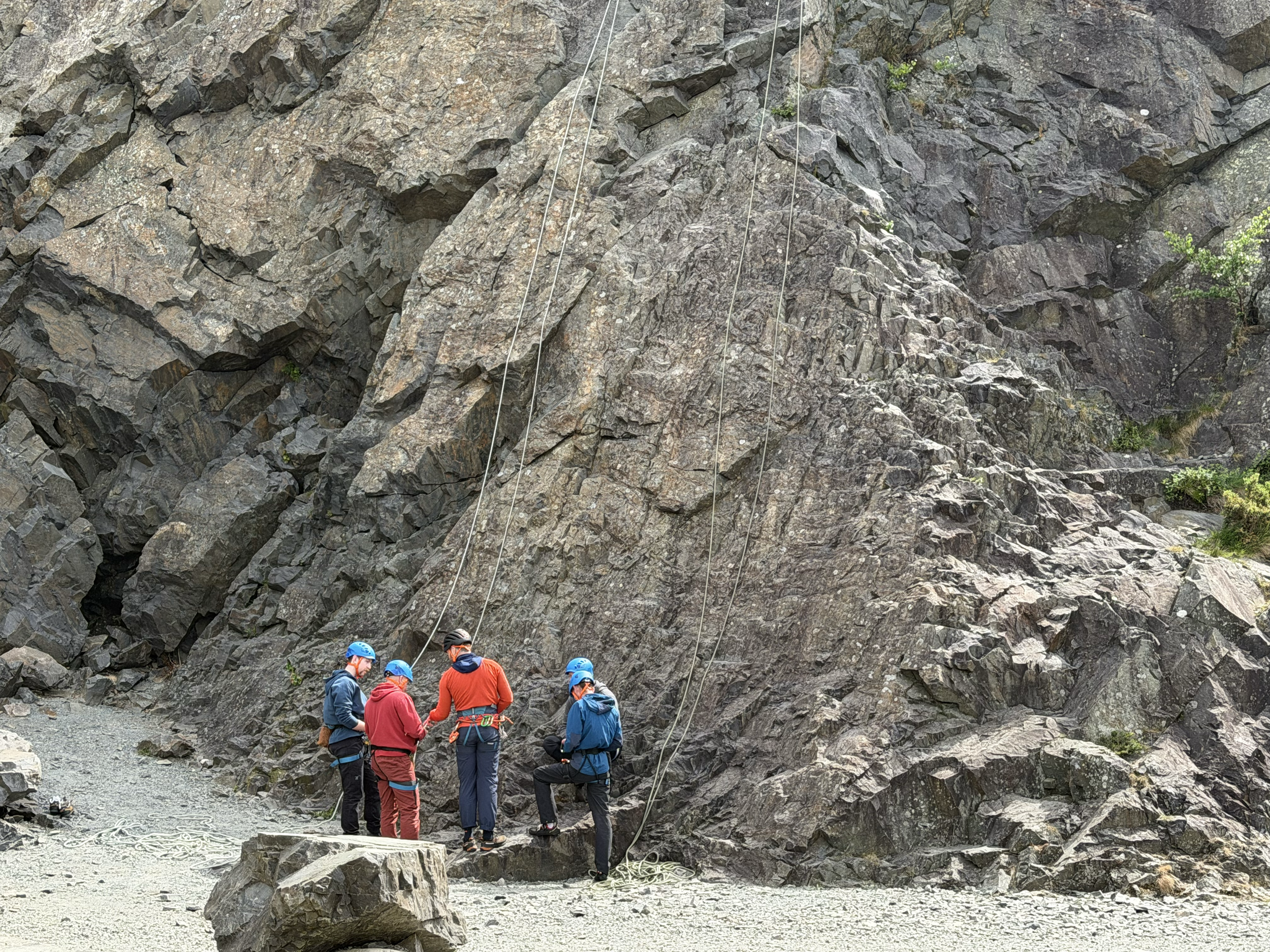Climbers under instruction at the base of a cliff