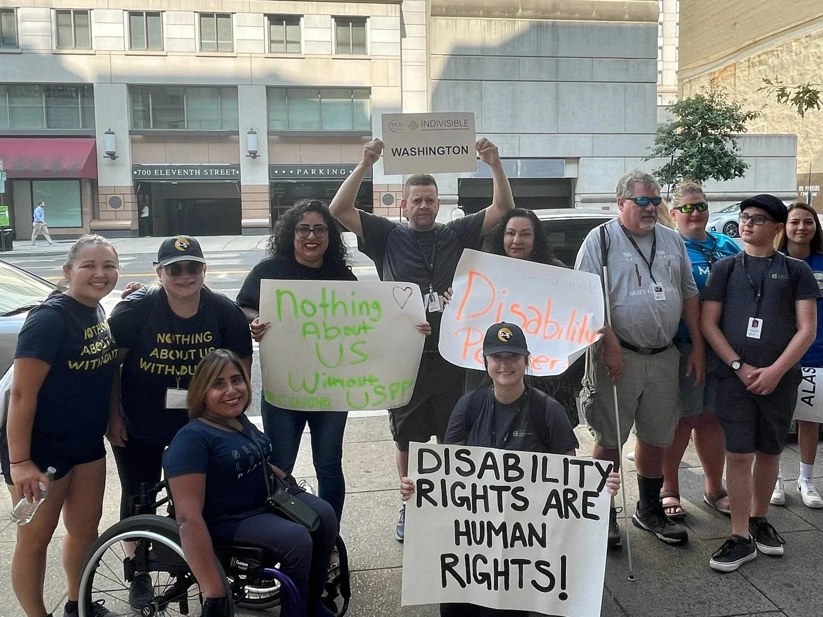 Group of people with disabilities gathering with signs at an event