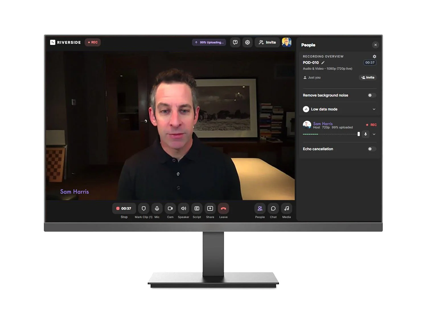 Computer monitor showing a video call with a man named Sam Harris. The background appears to be a dimly lit room with a framed picture and bookshelf. The user interface displays recording status, participant controls, and chat options.