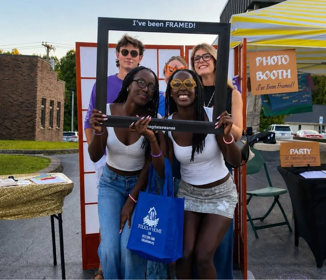 a AI-enhanced photograph of university of the south sewanee freshmen visiting frame gallery gifts & art's tent posing inside a frame with the words "i've been framed"