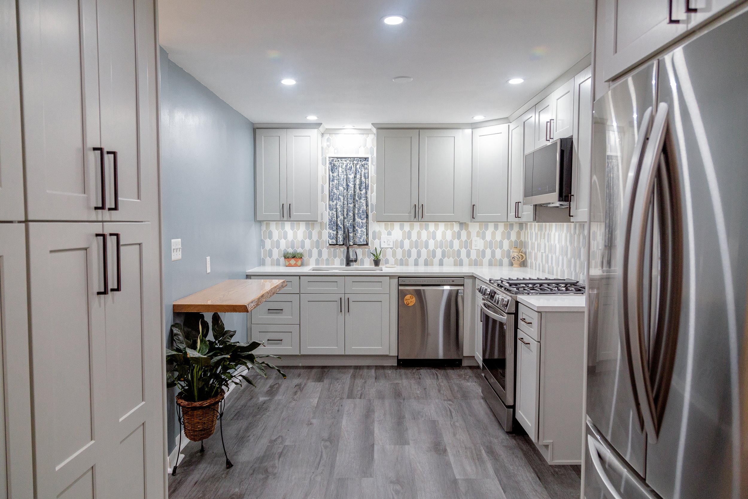 Remodeling the kitchen and dining room of a 1950s Cape Cod in Pittsburgh, PA. Design elements feature gray cabinets, oil-rubbed bronze hardware, neutral-tone picket tile, a live-edge oak slab floating table, and gray floors