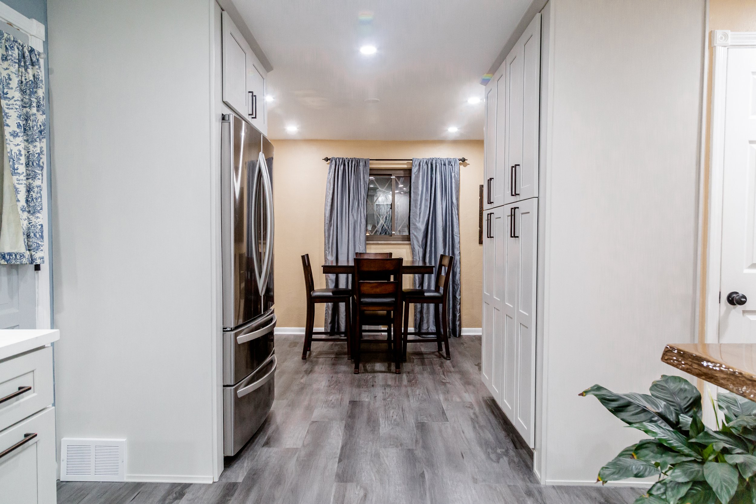 Remodeling the kitchen and dining room of a 1950s Cape Cod in Pittsburgh, PA. Design elements feature gray cabinets, oil-rubbed bronze hardware, neutral-tone picket tile, a live-edge oak slab floating table, and gray floors