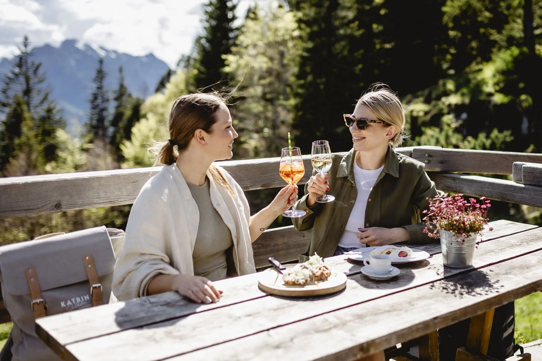 Zwei Freundinnen beim Anstoßen auf der Katrin Almhütte