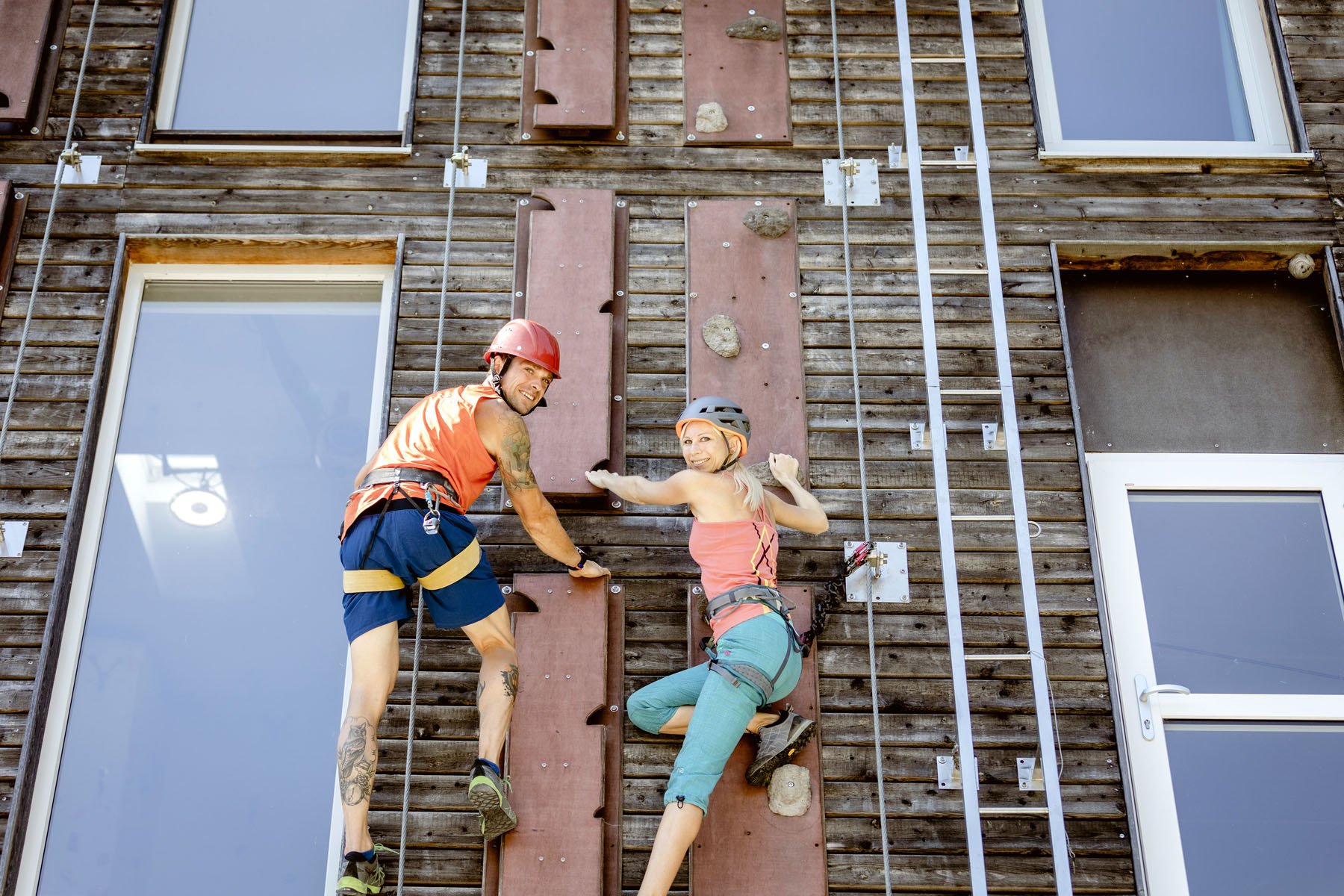 Katrin Bett&Berg und Kletterhalle, eine Frau und ein Mann klettern auf der Fassade 