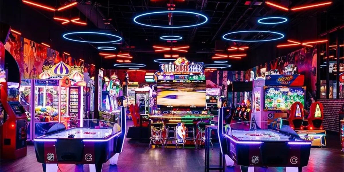 Vibrant arcade and entertainment facility at Chelsea Piers activities featuring bowling, arcade games, laser tag, and NBA-themed gaming stations with neon lighting and interactive sports simulators.