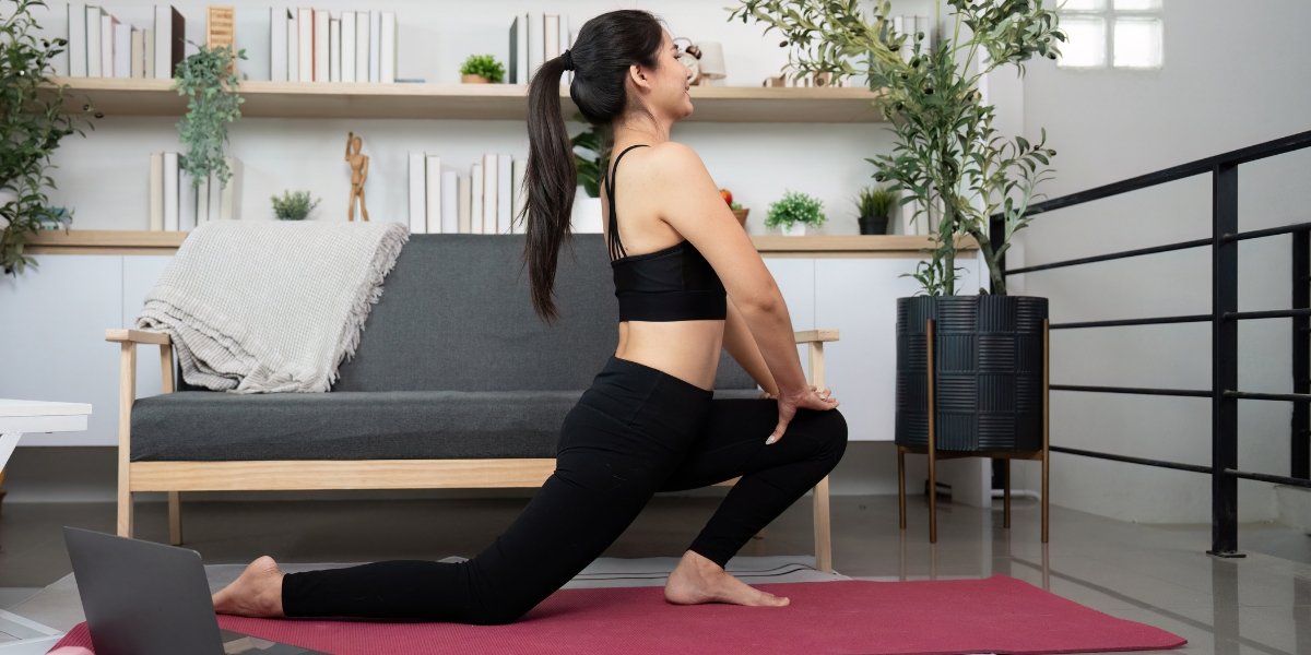 A woman performs a deep lunge stretch on a yoga mat at home, illustrating flexibility differences often discussed in Dynamic Stretches vs Static Stretches.