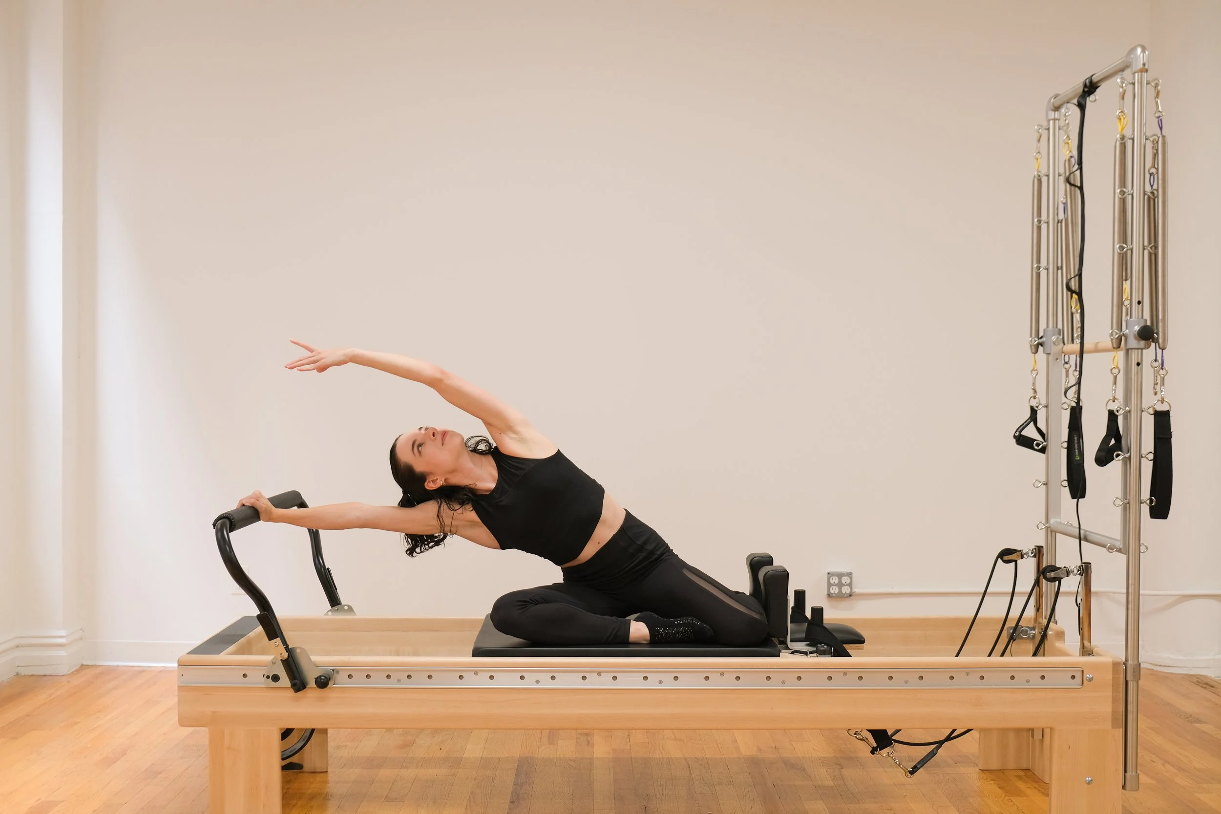 Client performing a supported leg movement on a reformer to reduce nerve tension during Pilates for sciatica
