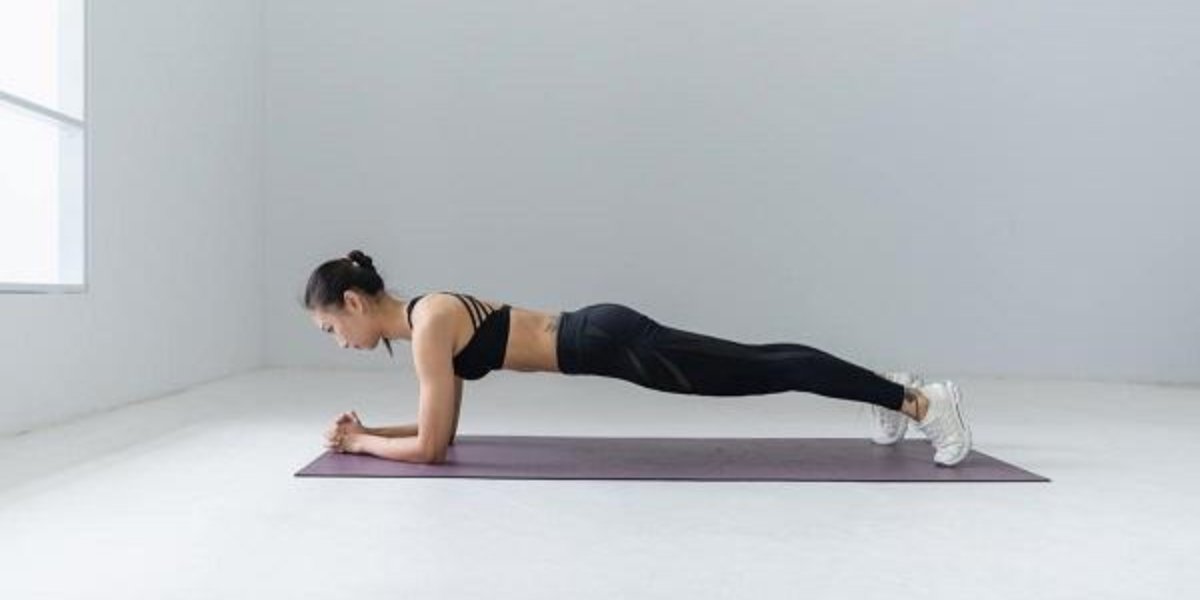 Woman performing a plank exercise on a purple mat in a bright minimalist studio, maintaining proper body alignment for core strength and stability
