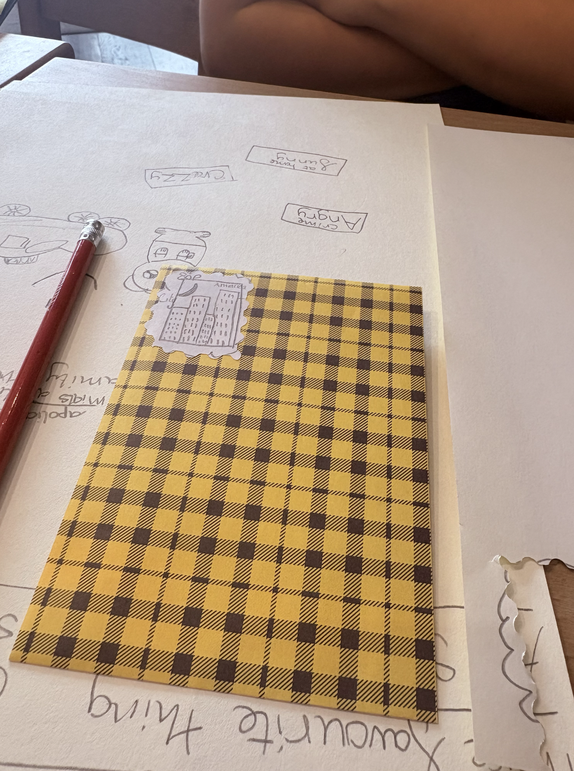 Cute and imaginative drawings on checkered envelope with handmade stamp created in childrens creative club Story Spark by cartoonist and author Sam Hepburn at Read on Sea bookshop in Leigh on Sea Essex