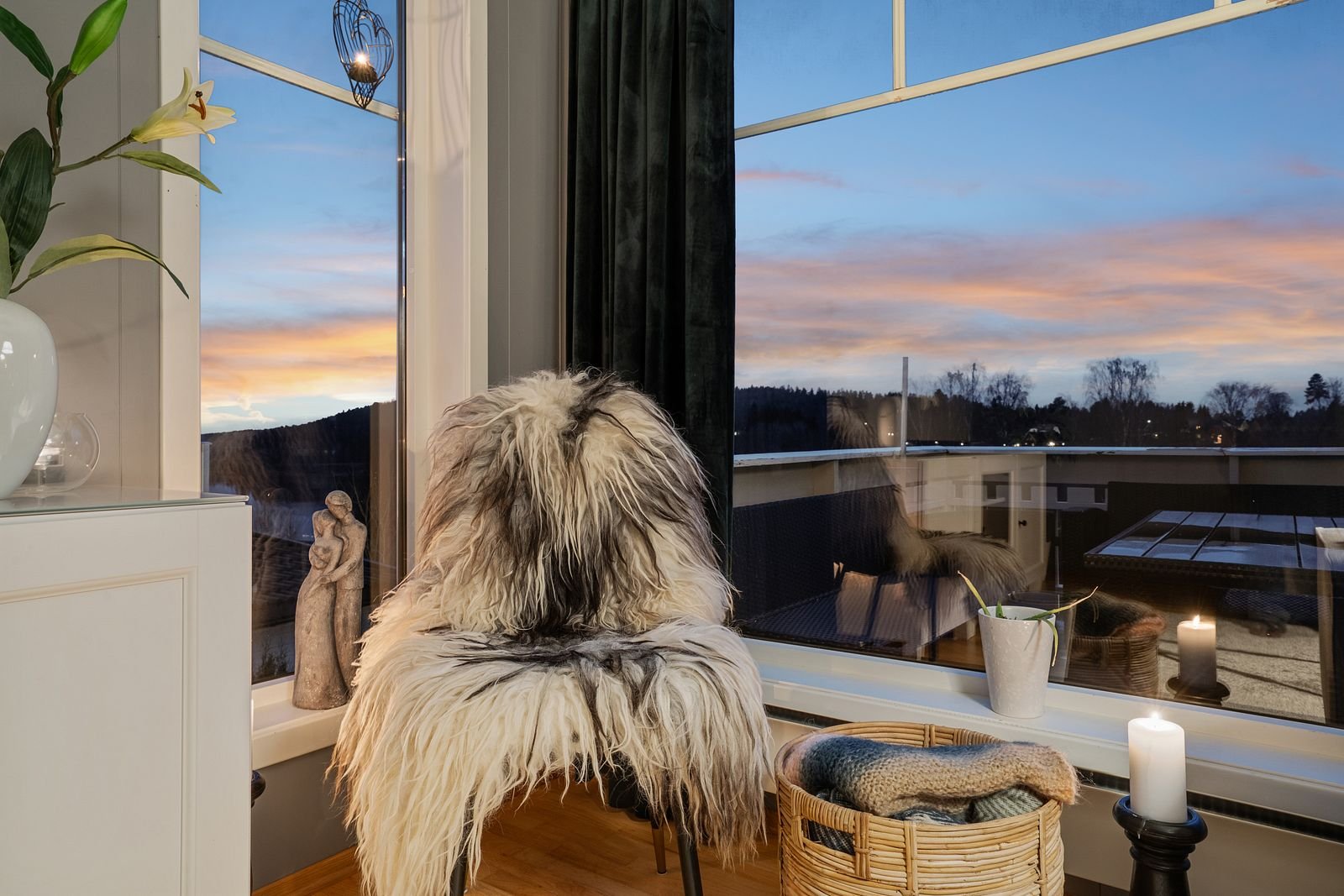 Har man utsikt så må den benyttes. Her brukes det en vanlig stol, pledd og levende lys for å skape noe varmt