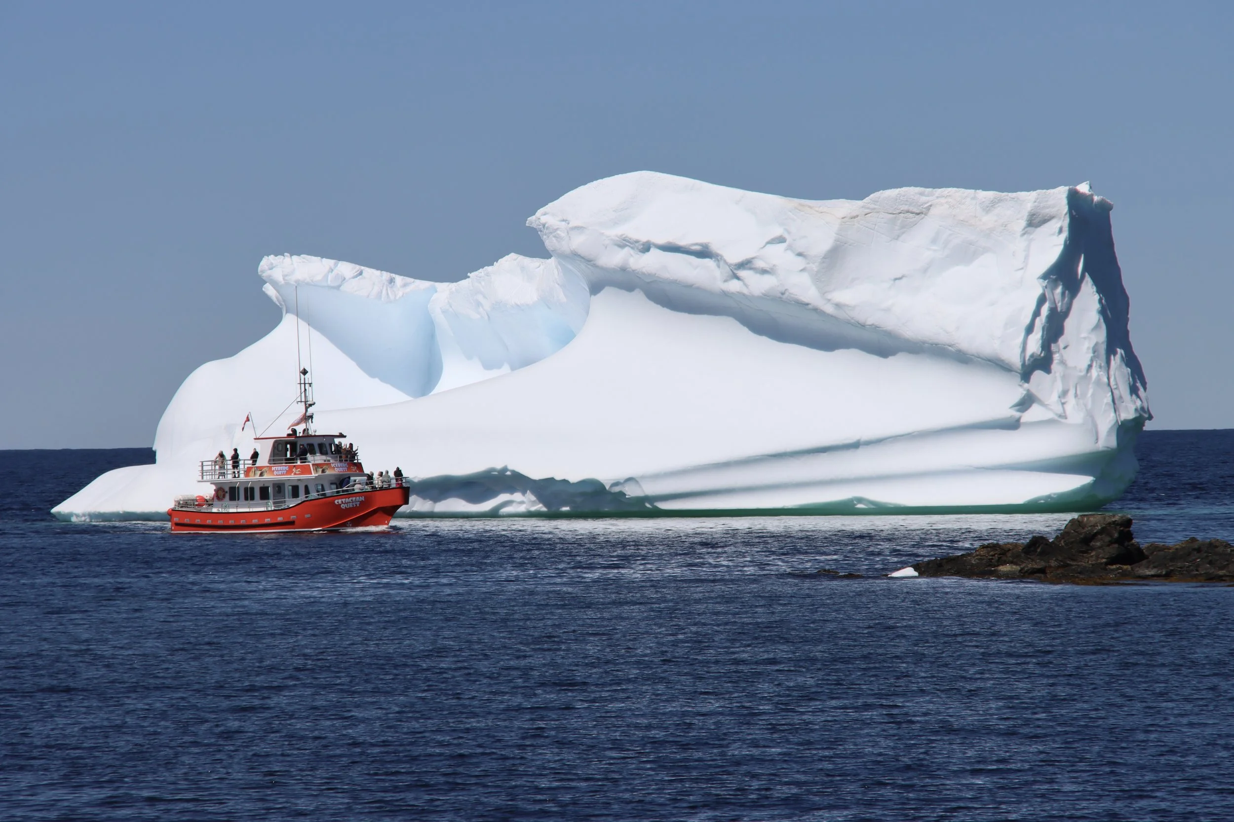 Iceberg and tour boat in Twillingate, NL