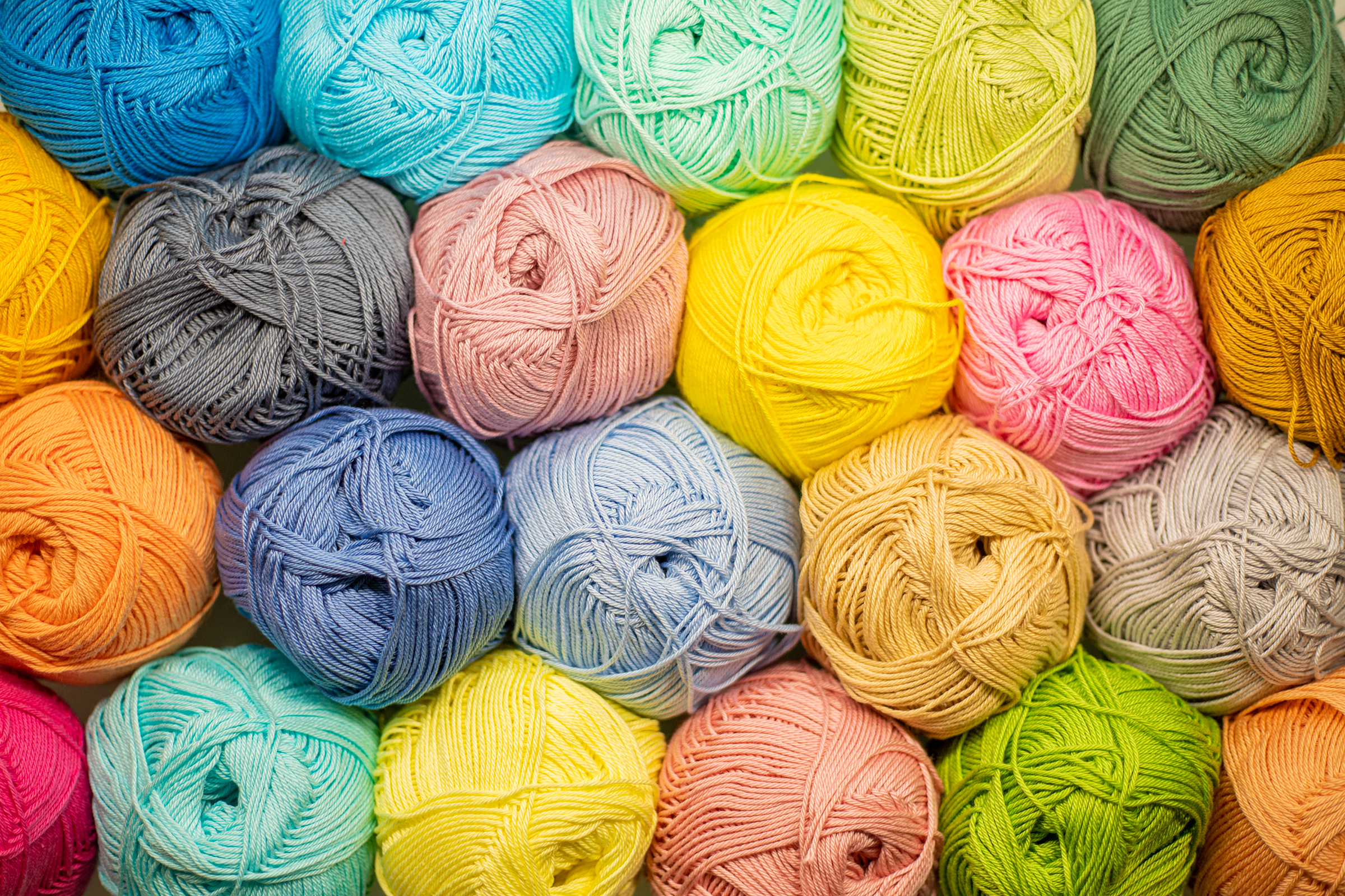 background-from-colored-yarn-balls-thread-closeup-materials-needlework-rack-with-yarn-store-shelf-with-multicolored-threads-knitting.jpg_2400.png