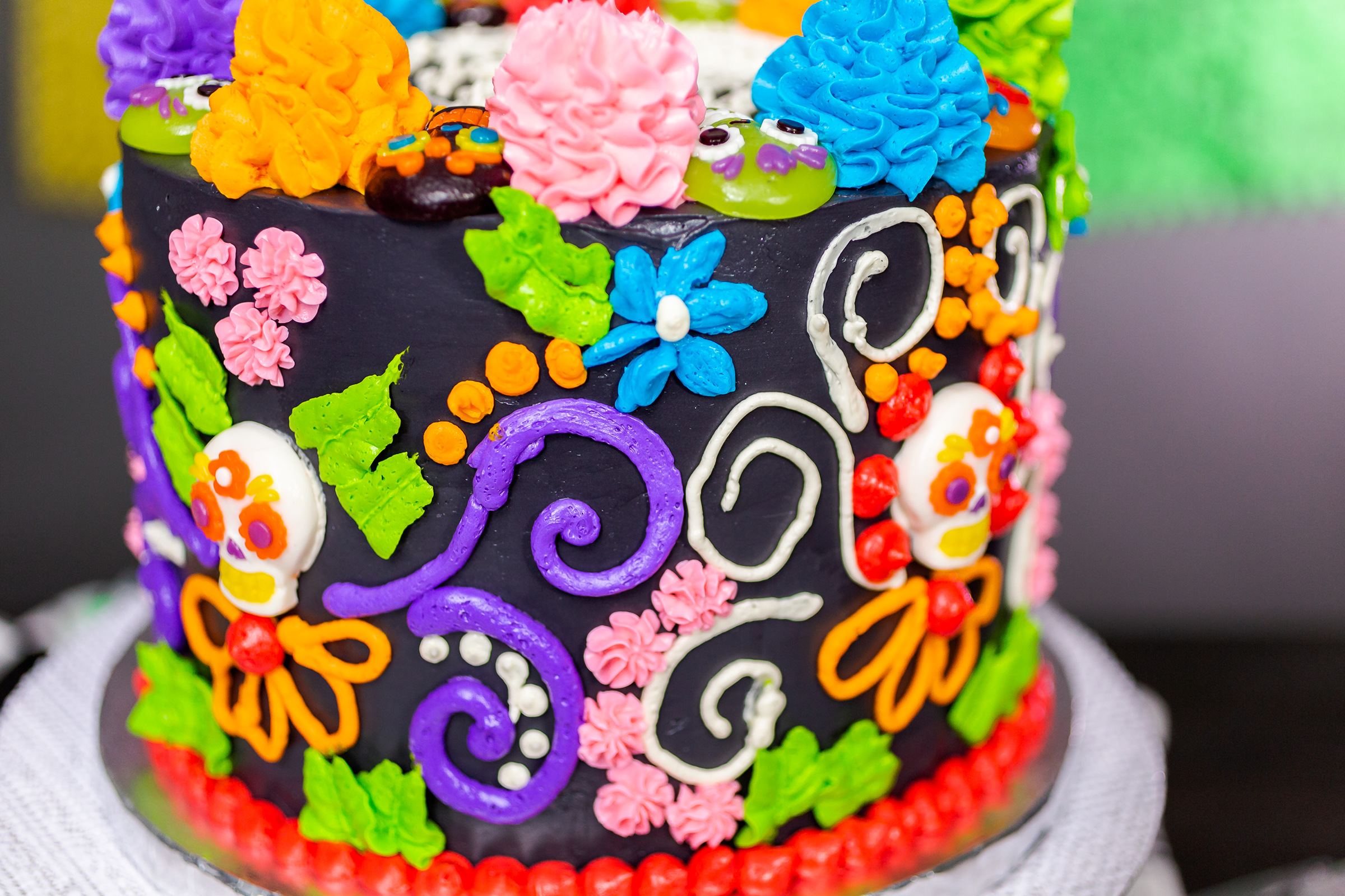 gourmet-dia-de-los-muertos-cake-decorated-with-colorful-buttercream-frosting-gummy-cupcake-toppers_2400.png