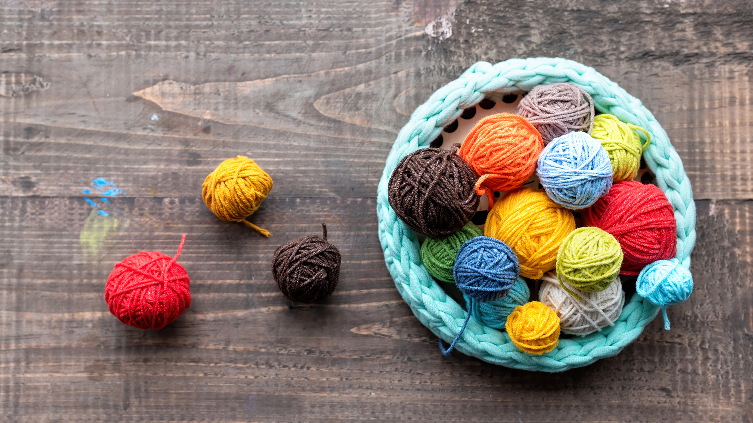 multicolored-balls-yarn-near-knitted-couch_2400.png
