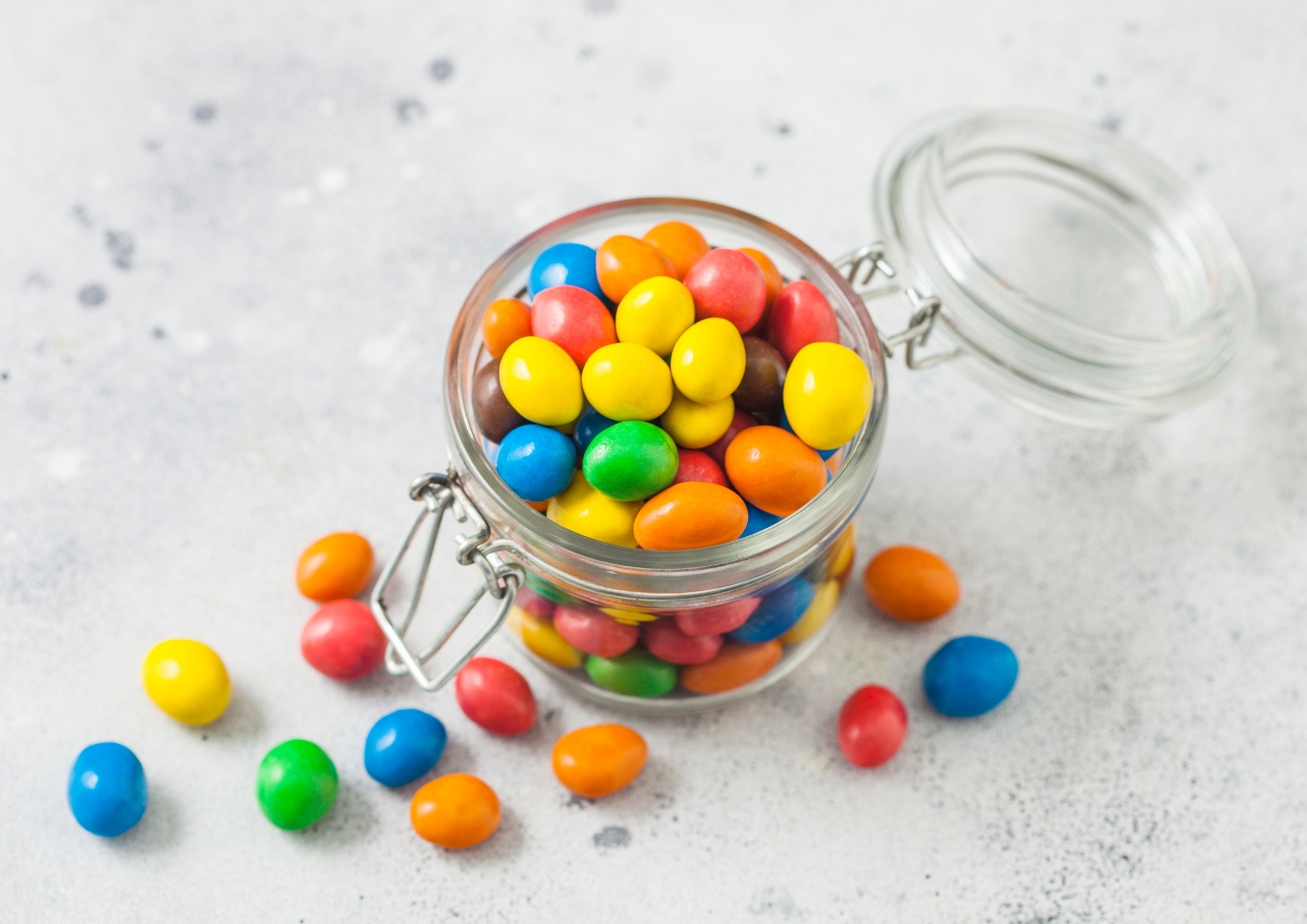 various-milk-chocolate-sweet-candies-with-rice-centre-sugar-shell-glass-jar-light-table-top-view_2400.png