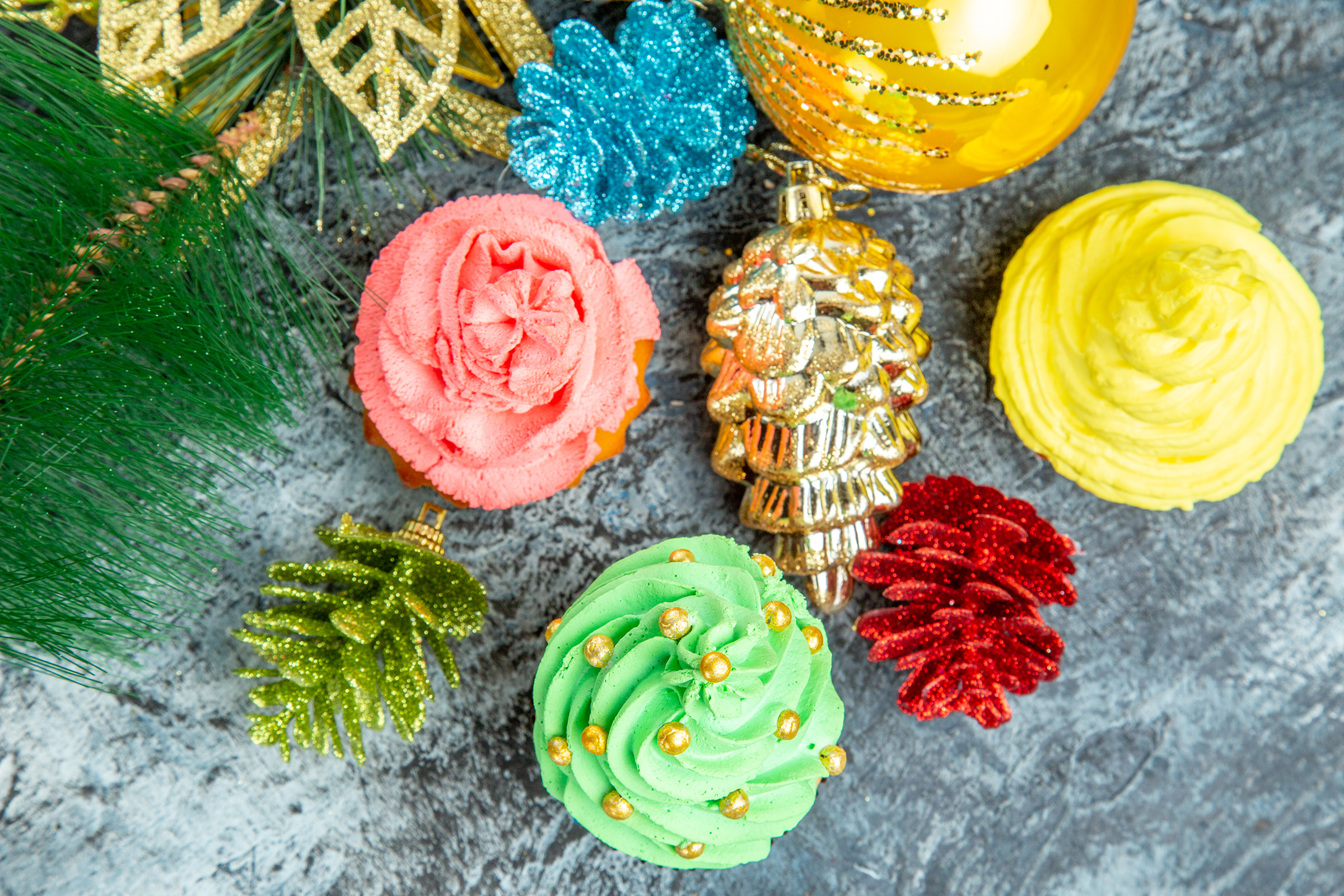top-close-view-colorful-cupcakes-xmas-ornaments-grey-background_2400.png