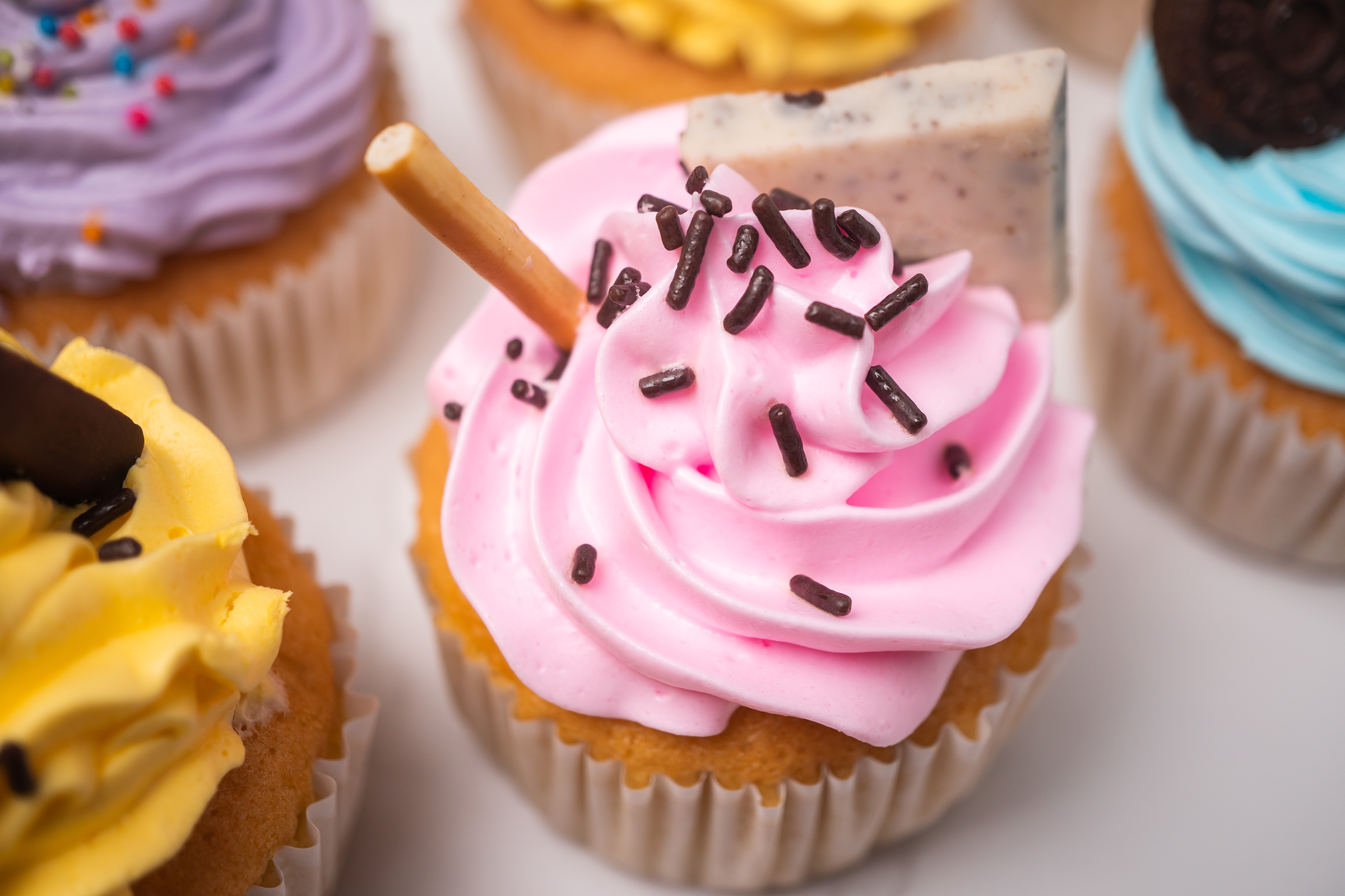 delicious-homemade-cupcakes-with-colorful-cream-topping-with-candy-chocolate-cookies_2400.png
