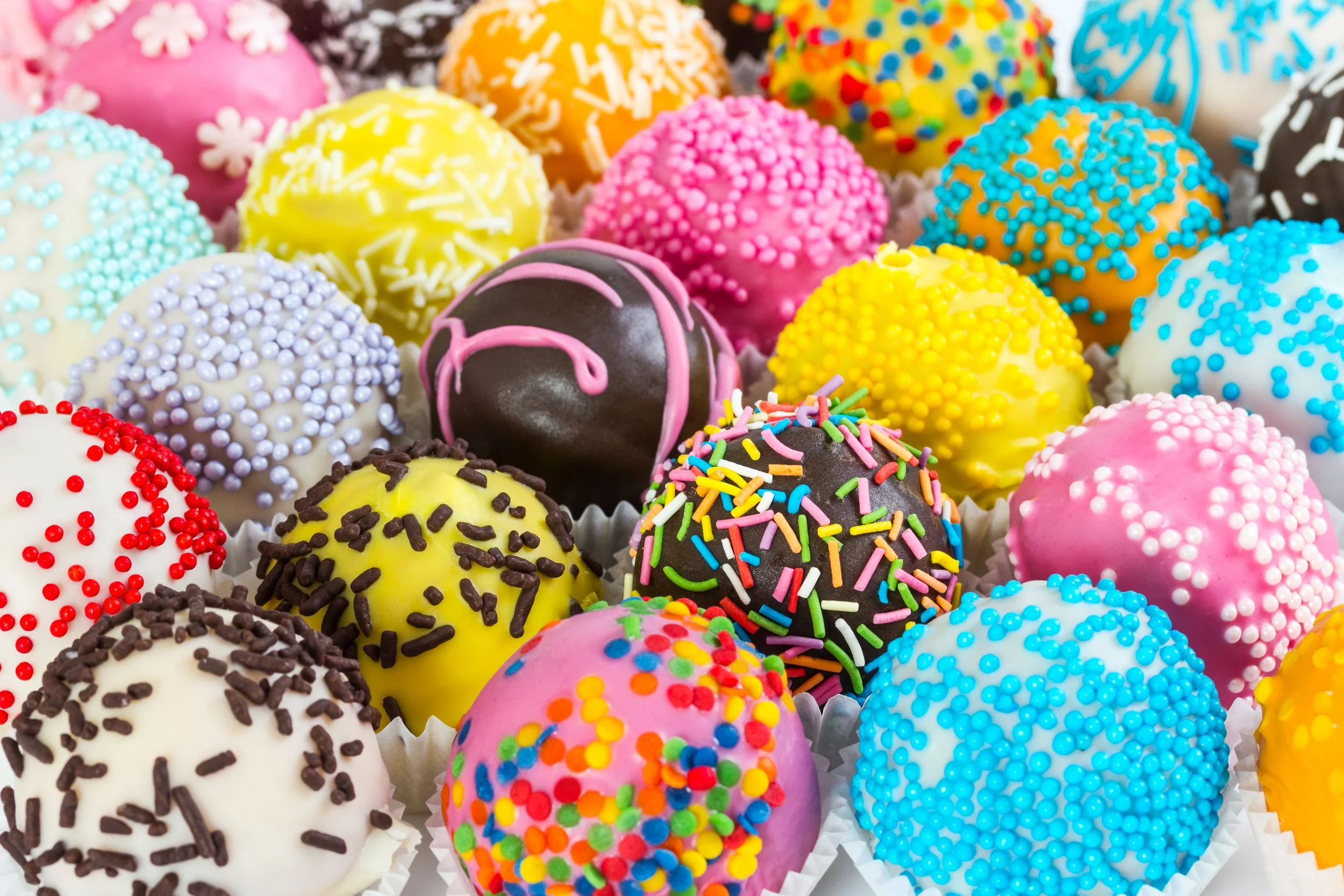different-colorful-cake-balls-with-decorative-sprinkles-paper-form.jpg