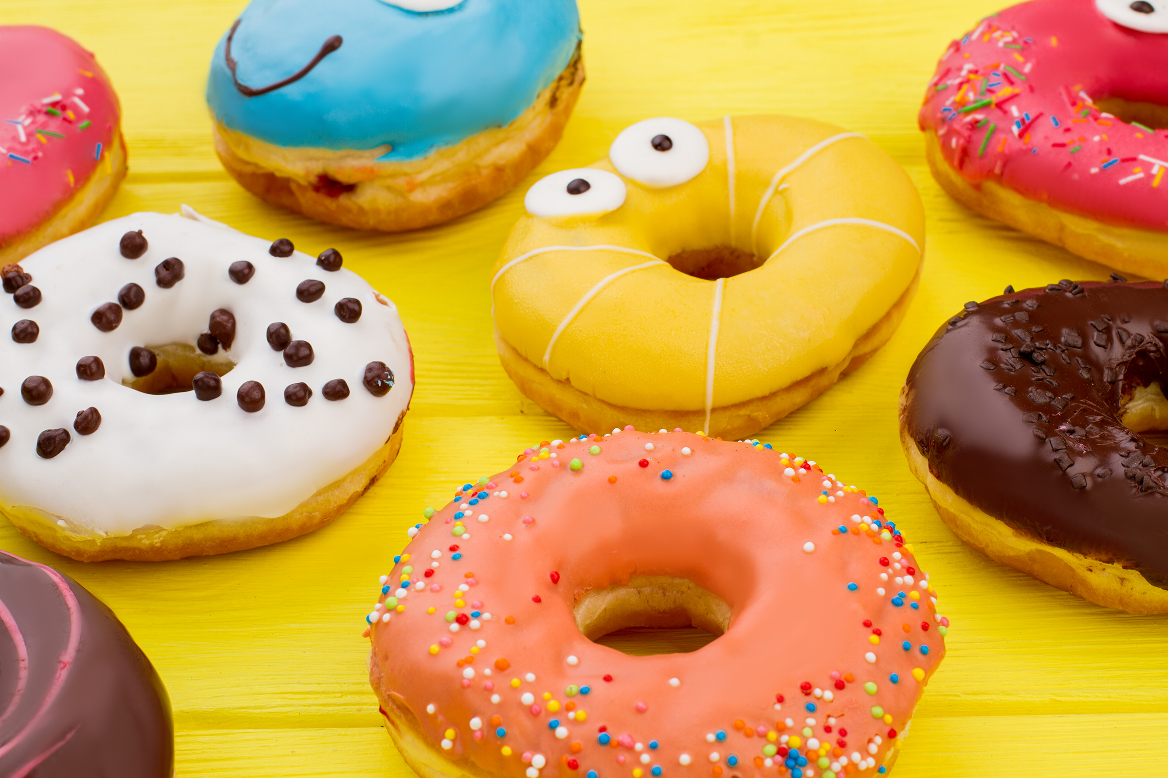 background-multicolored-glazed-donuts-delicious-frostred-cakes-color-wooden-surface_2400.png