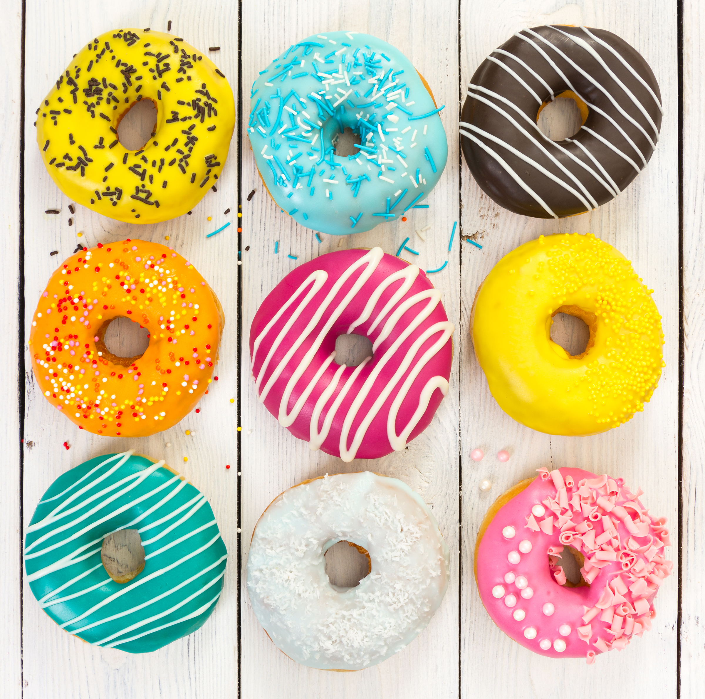different-colorful-donuts-light-wooden-background_2400.png