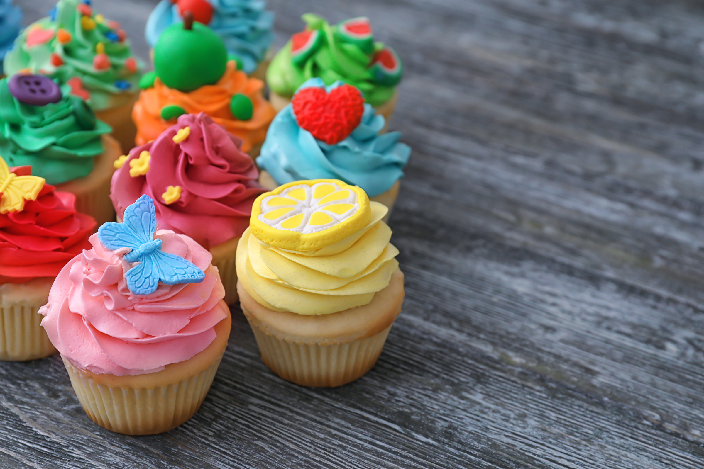 tasty-colorful-cupcakes-wooden-table_2400.png