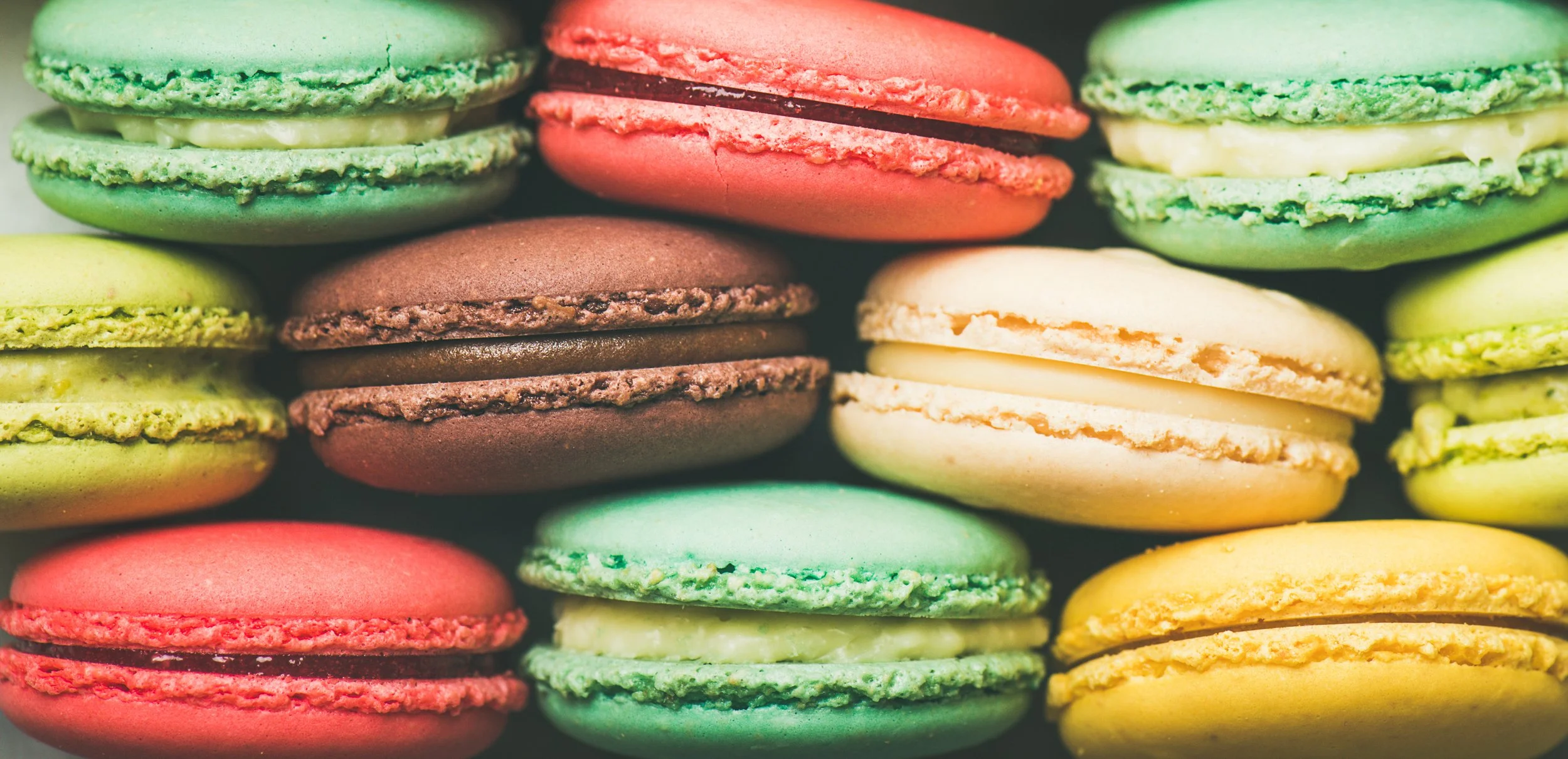 colorful-french-macaroons-cookies-stacked-rows-wide-composition.jpg