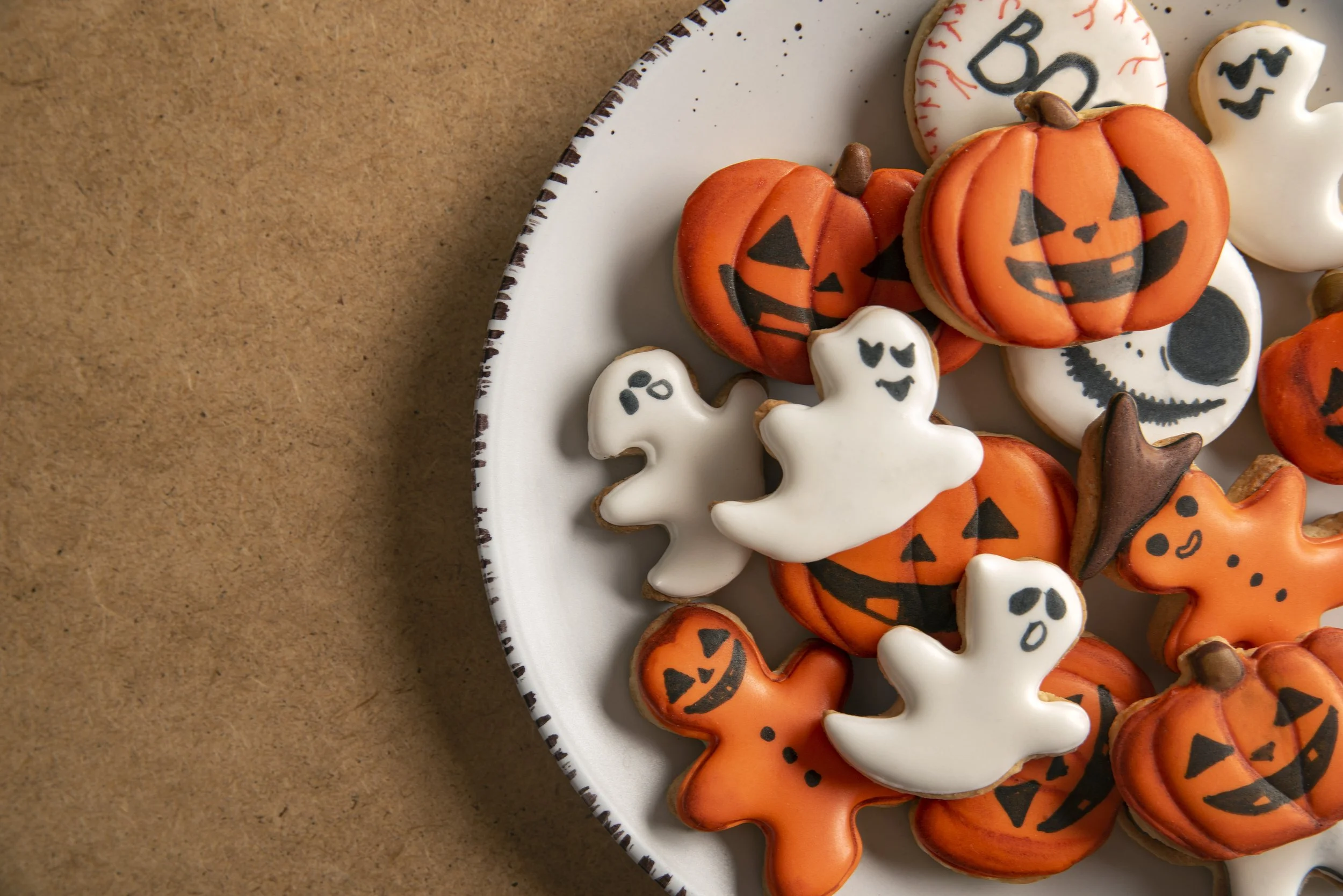 plate-with-orange-halloween-cookies-shape-pumpkin-ghosts-big-plate-place-text-top-view.jpg