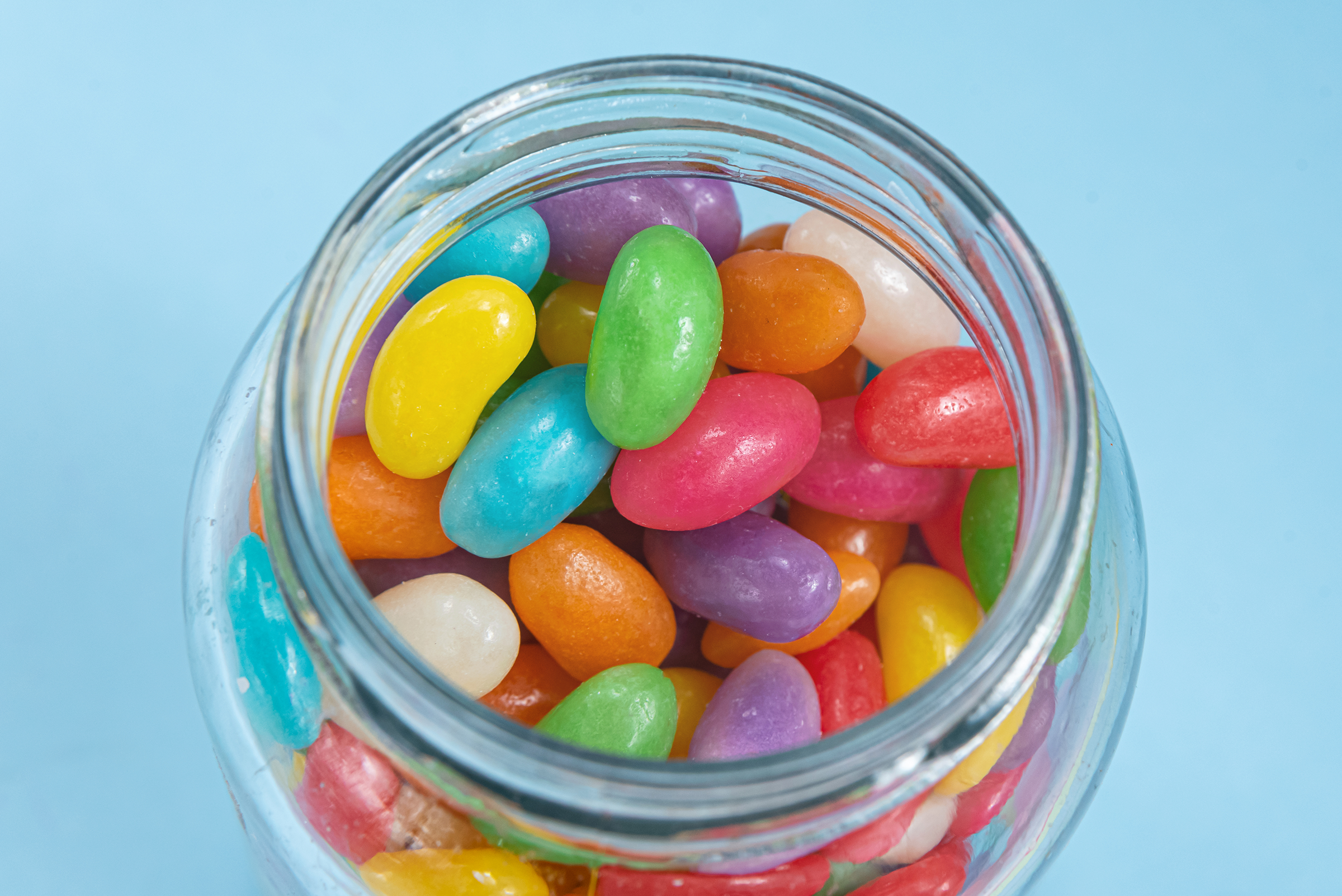 several-jelly-beans-blue-background-inside-glass-pot_2400.png