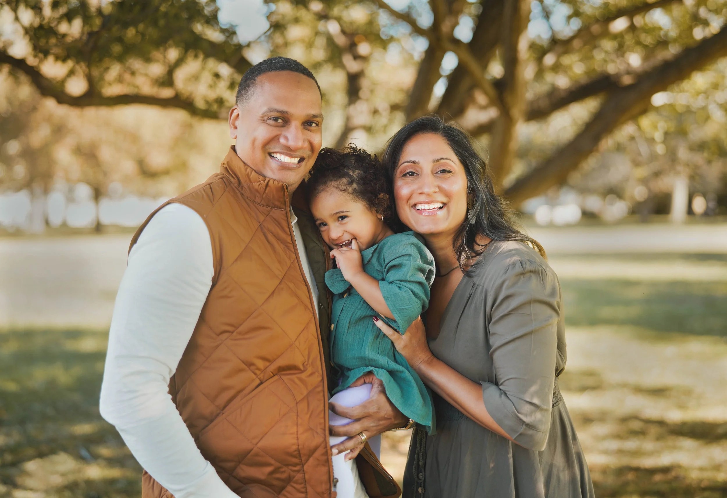 Family standing in front of tree.